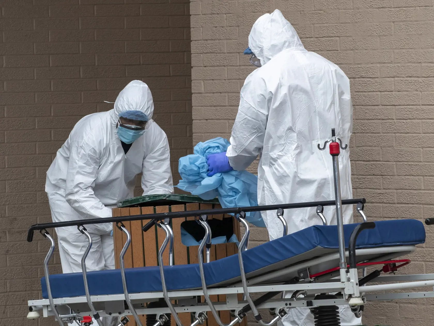 JB 17 New York - Zdravotníci zhadzujú svoj ochranný odev po tom, ako prepravili telá obetí pandémie koronavírusu zo zdravotníckeho zariadenia Wycoff Heights Medical Center do chladiarenských kontajnerov pred nemocnicou v New Yorku 2. apríla 2020. Spojené štáty patria medzi krajiny, ktoré epidémia koronavírusu postihla najviac. Novým druhom koronavírusu je tam nakazených najmenej 215.000 ľudí a viac ako 5000 následkom nákazy už podľahlo. FOTO TASR/AP

Medical personnel remove their personal prote