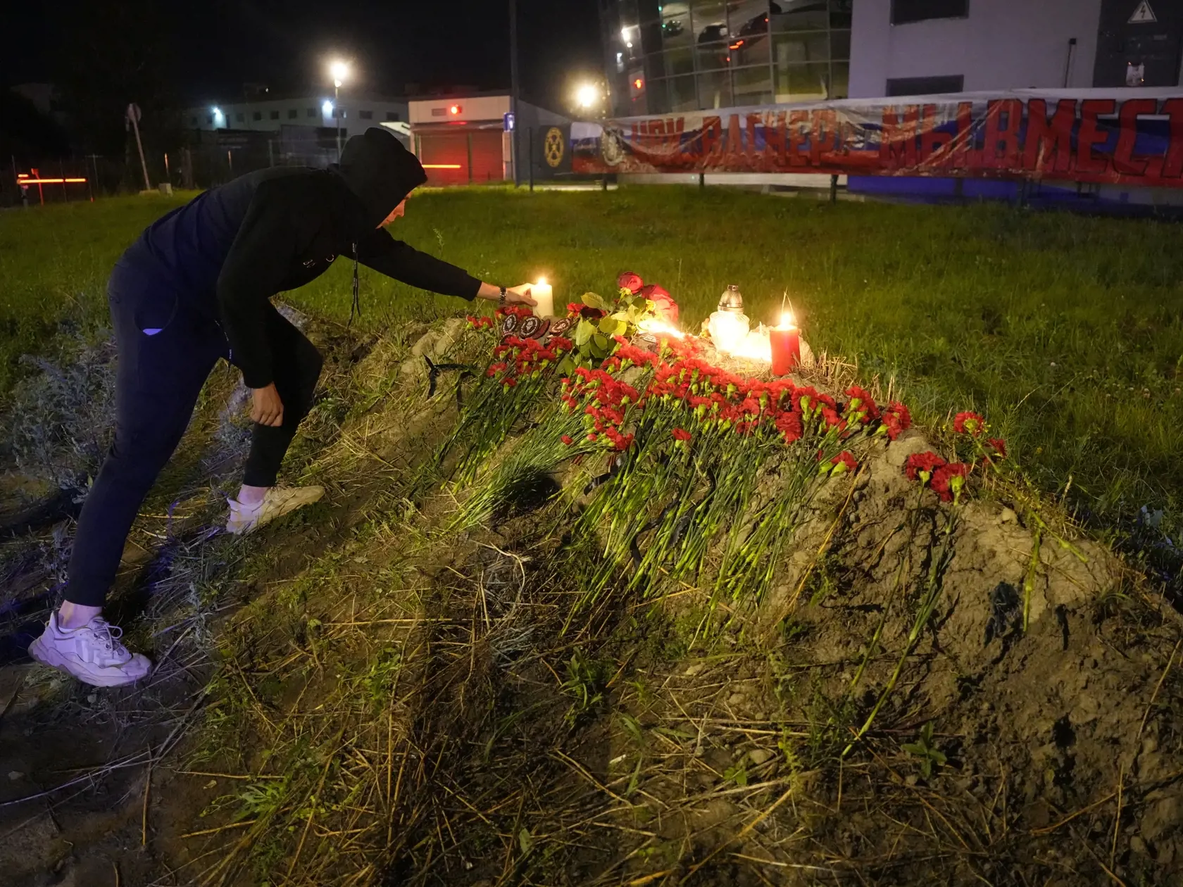 KK9 Petrohrad - Muž zapaľuje sviečku pred Vagnerovým obchodným centrom 24. augusta 2023 v Petrohrade. Šéf ruskej žoldnierskej Vagnerovej skupiny Jevgenij Prigožin sa podľa ruských úradov nachádzal na palube lietadla Embraer-135, ktoré sa v stredu zrútilo v Tverskej oblasti blízko Moskvy. Haváriu nikto neprežil. Prigožinova smrť však doposiaľ nebola oficiálne potvrdená. Na palube bolo desať ľudí vrátane troch členov posádky. FOTO TASR/AP
A man lights a candle at an informal memorial next to the f