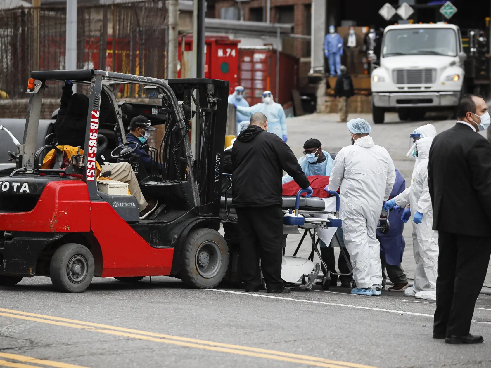 JB 20 New York - Telo obete zakryté prikrývkou po vyložení z mraziarenského nákladného auta zdravotníci tlačia na nosidlách v New Yorku 31. marca 2020. Spojené štáty patria medzi krajiny, ktoré epidémia koronavírusu postihla najviac. Novým druhom koronavírusu je tam nakazených najmenej 164.714 ľudí a viac ako 3000 následkom nákazy už podľahlo. FOTO TASR/AP

A body wrapped in plastic that was unloaded from a refrigerated truck is handled by medical workers wearing personal protective equipment du