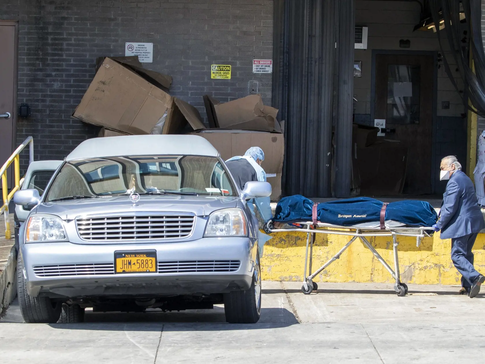 JB 24 New York - Riaditeľ pohrebných služieb a zamestnanec zdravotníckeho zariadenia Wycoff Heights Medical Center prepravujú telo obete pandémie koronavírusu do pohrebného auta v New Yorku 1. apríla 2020. Spojené štáty patria medzi krajiny, ktoré epidémia koronavírusu postihla najviac. Novým druhom koronavírusu je tam nakazených najmenej 188.881 ľudí a viac ako 4000 následkom nákazy už podľahlo. FOTO TASR/AP

A funeral director and a Wycoff Heights Medical Center, employee transport a body into
