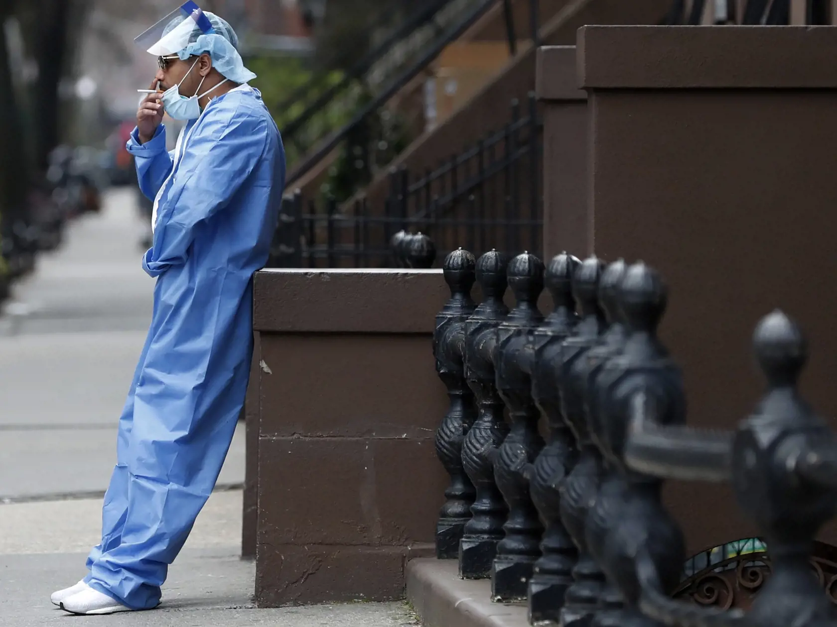 JB 11 New York - Zdravotný brat na pohotovosti  Brian Stephen v ochrannom odeve fajčí počas prestávky pred zdravotníckym zariadením Brooklyn Hospital Center v New Yorku 5. apríla 2020. Americký prezident Donald Trump, ktorého administratíva čelí rovnako ako úrady vo viacerých štátoch kritike, že na šírenie nákazy dostatočne rýchlo nezareagovali, sa na nedeľňajšom večernom brífingu v Bielom dome vyjadril k situácii optimistickejšie než predtým viacerí predstavitelia zdravotníctva. "Začíname vidie