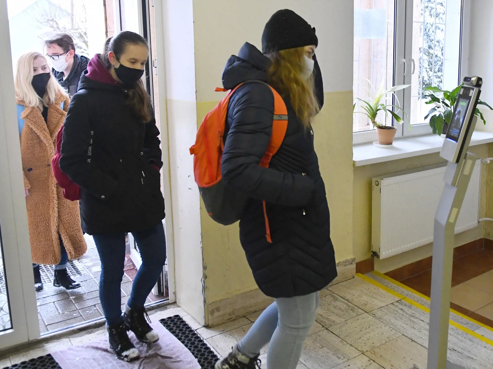 Niektoré školy sa od pondelka 8. februára 2021 otvorili. Ide najmä o materské školy, prvý stupeň základných škôl a končiace ročníky stredných škôl. Na snímke maturantka s ochranným rúškom si meria telesnú teplotu pri vstupe do školy na Gymnáziu Jána Adama Raymana v Prešove v utorok 9. februára 2021. FOTO TASR - Milan Kapusta

