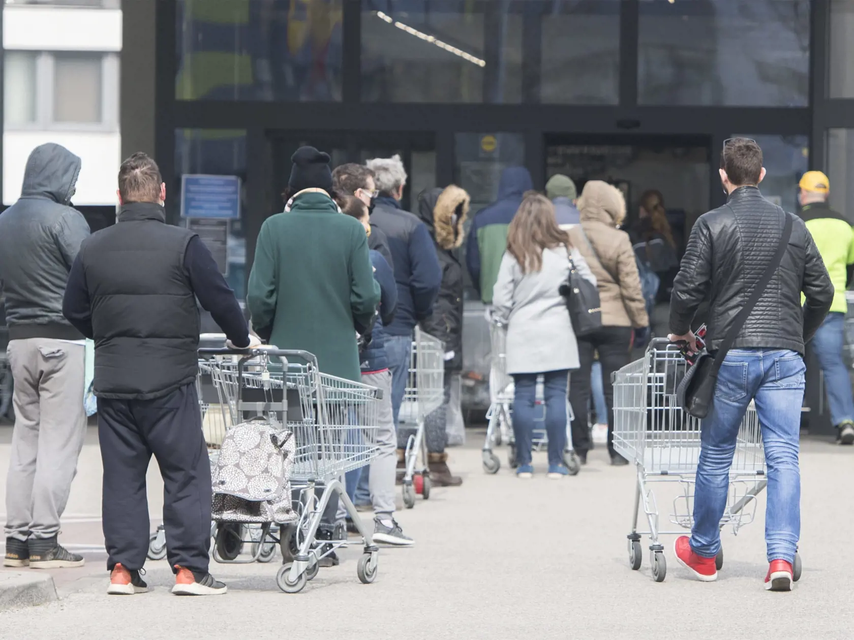 Na snímke čakajúci ľudia stoja v rade pred obchodom. Obchody na Slovensku regulujú vstupy kvôli vírusu Covid-19.