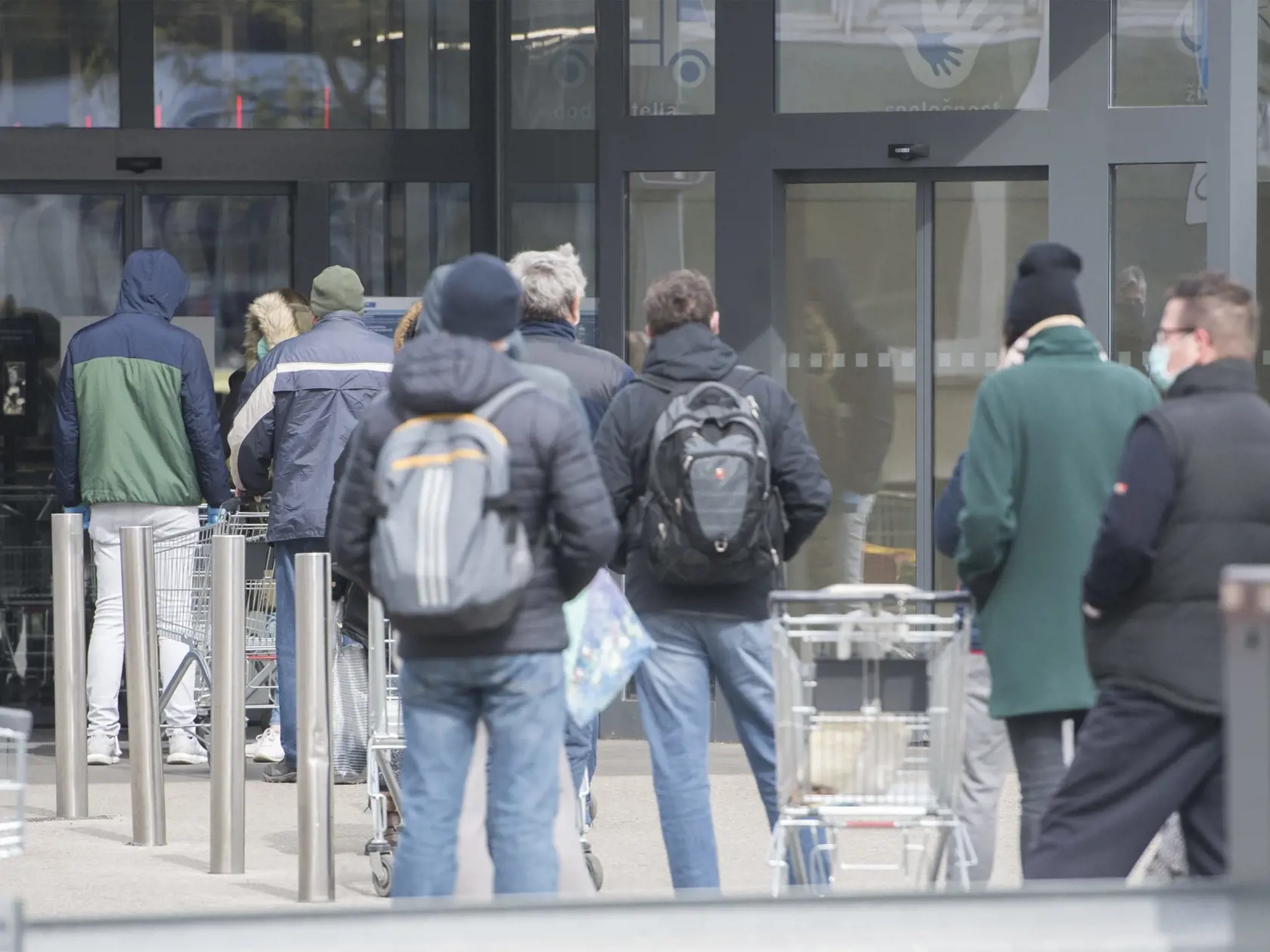 Na snímke čakajúci ľudia stoja v rade pred obchodom. Obchody na Slovensku regulujú vstupy kvôli vírusu Covid-19.