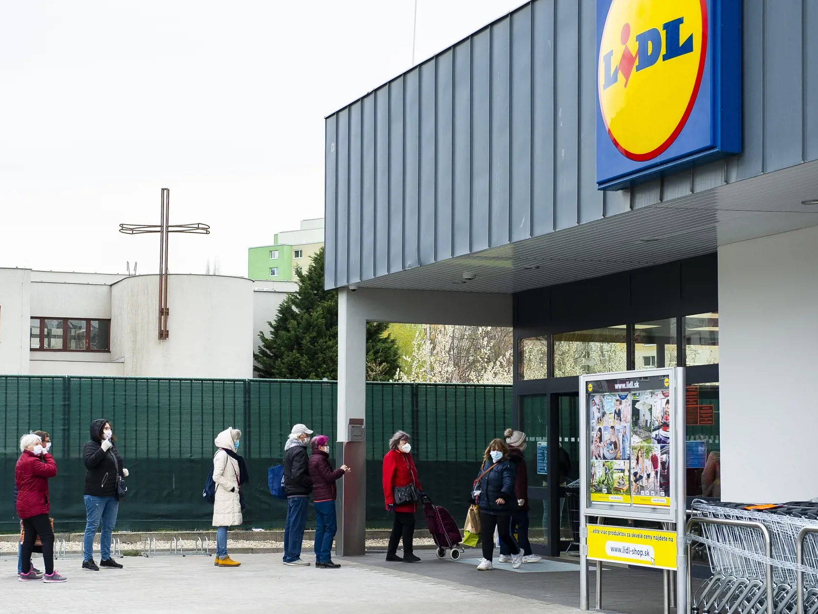 Na snímke zákazníci supermarketu Lidl čakajúci v rade v odstupoch.