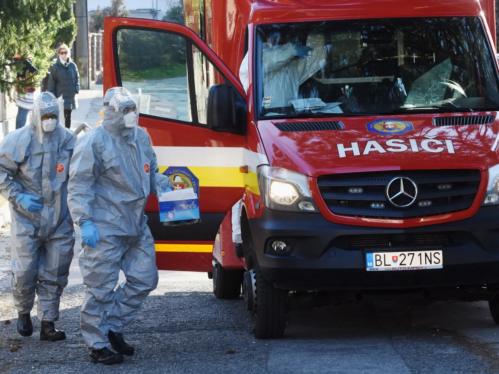 Na snímke sú hasiči, ktorí idú odobrať vzorky mobilným zariadením od pacienta podozrivého na ochorenie na koronavírus v jednej z bratislavských štvrtí.