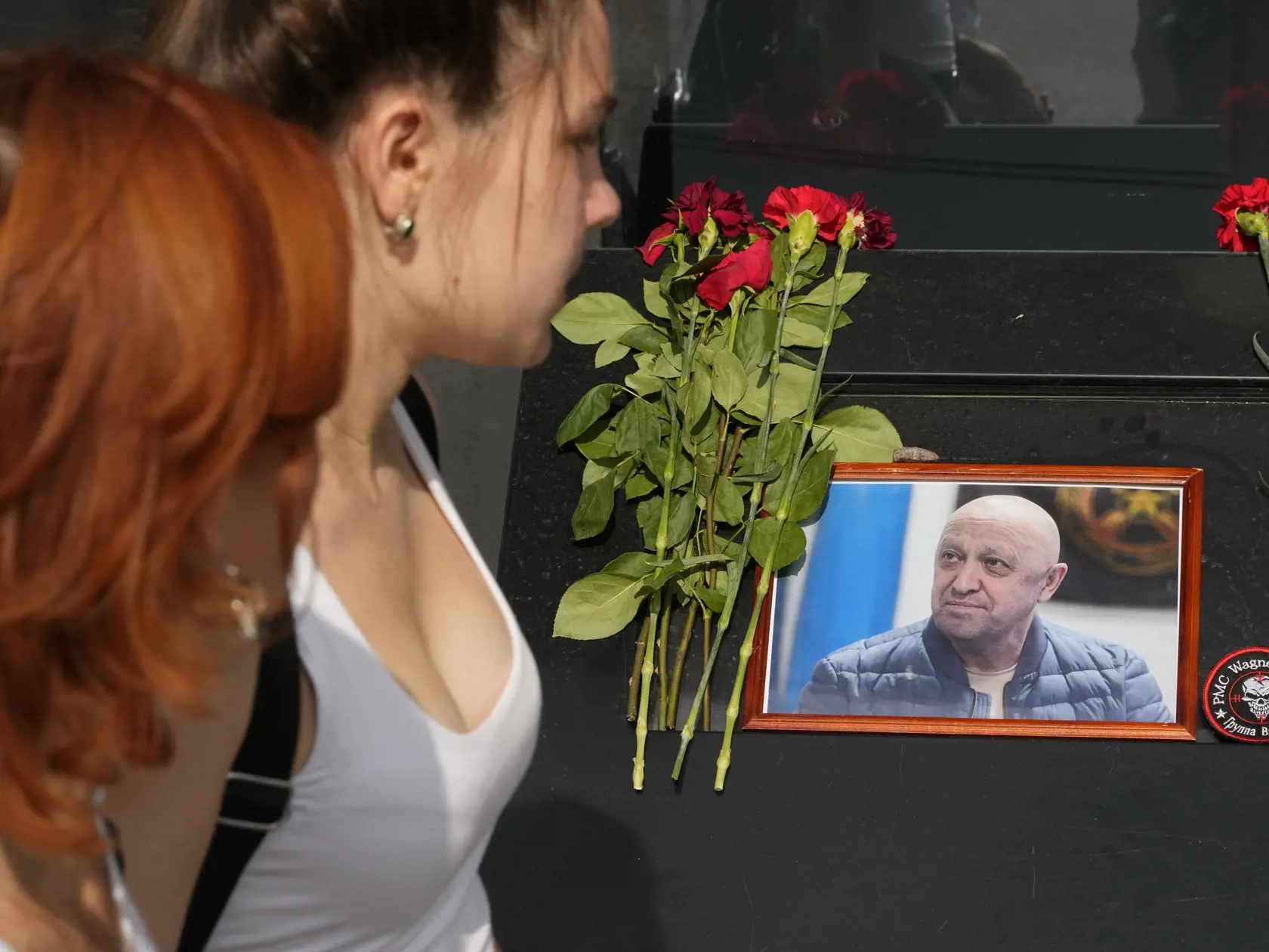 KK7 Petrohrad - Ženy kráčajú okolo portréta šéfa žoldnierskej Vagnerovej skupiny Jevgenija Prigožina v kaviarni patriacej Prigožinovej spoločnosti v ruskom Petrohrade v25. augusta 2023.  Súkromné lietadlo typu Embraer Legacy 600, ktoré malo patriť zakladateľovi vagnerovcov Jevgenijovi Prigožinovi, smerovalo v stredu 23. augusta z Moskvy do Petrohradu, kde majú sídlo jeho firmy, keď sa zrútilo nad Tverskou oblasťou na západe Ruska. Pád lietadla podľa informácií ruských úradov a médií neprežil nik