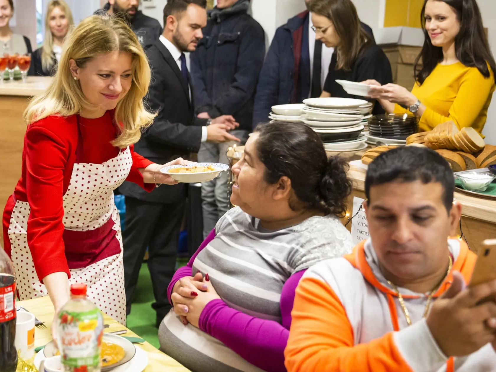 Na snímke prezidentka SR Zuzana Čaputová podáva vianočnú kapustnicu klientom centra počas návštevy zariadenia pre ľudí bez domova Domec, OZ Vagus v Bratislave 23. decembra 2019. FOTO TASR – Jaroslav Novák