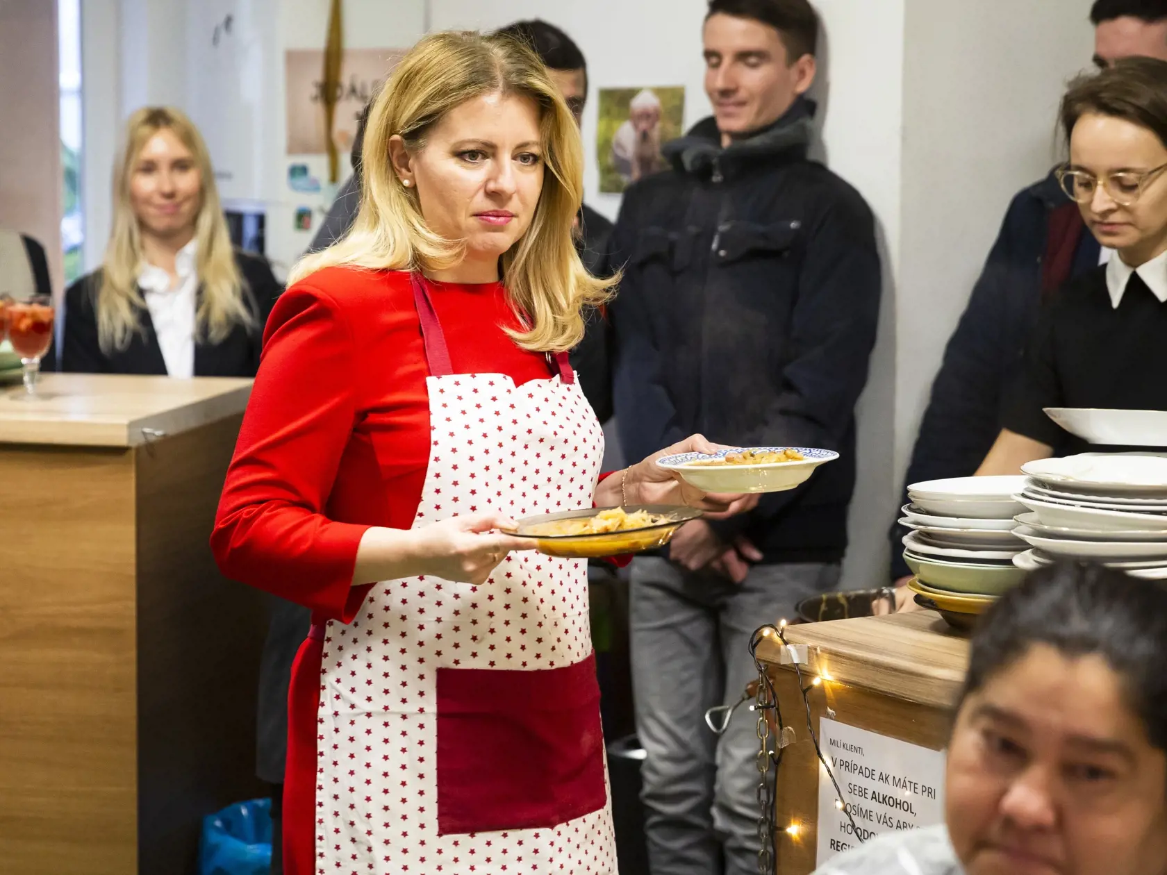 Na snímke prezidentka SR Zuzana Čaputová podáva vianočnú kapustnicu klientom centra počas návštevy zariadenia pre ľudí bez domova Domec, OZ Vagus v Bratislave 23. decembra 2019. FOTO TASR – Jaroslav Novák