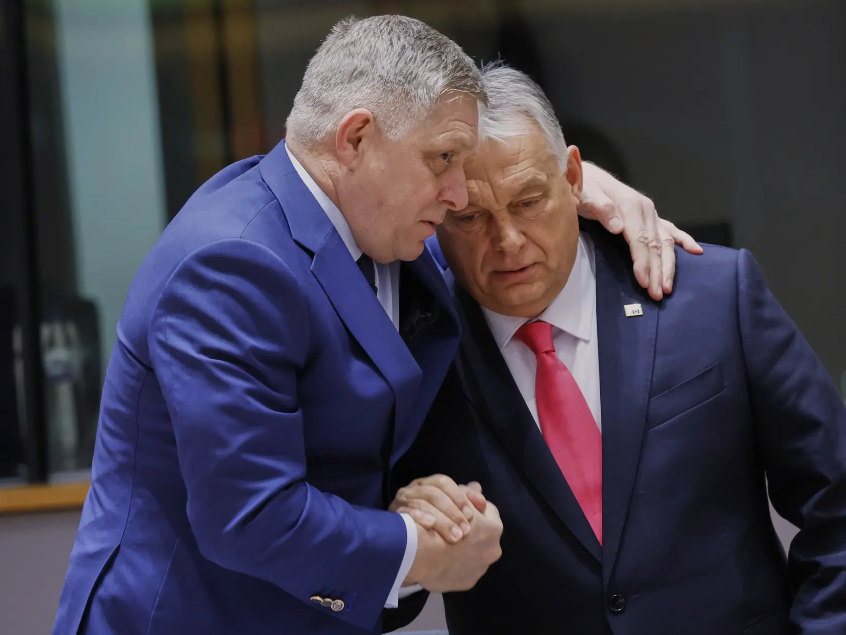 Slovenský premiér Robert Fico (vľavo) a maďarský premiér Viktor Orbán sa objímajú na summite EÚ v Bruseli vo štvrtok 20. marca 2025. 