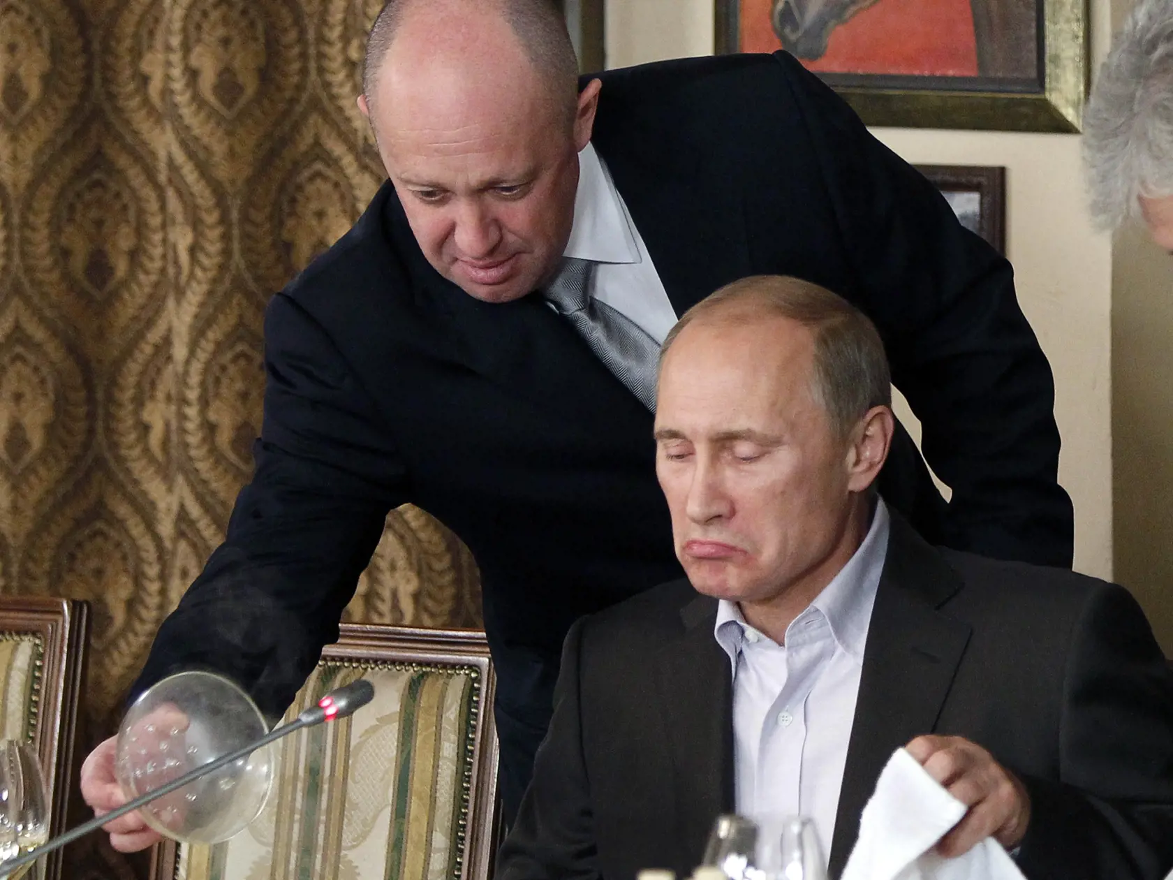 Na snímke z 11. novembra 2011 - Jevgenij Prigožin (vľavo) servíruje jedlo Vladimirovi Putinovi.