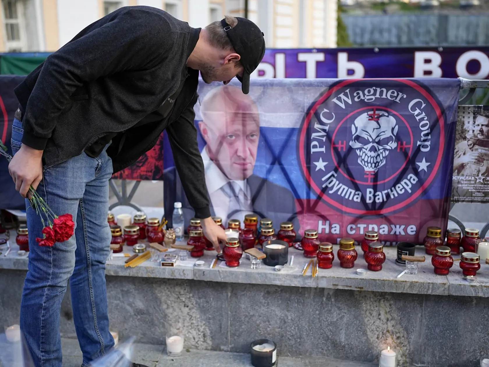 Moskva - Muž kladie sviečku k pouličnému pamätníku za členov Wagnerovej skupiny, ktorí zahynuli v stredu pri havárii lietadla, neďaleko Kremľa v nedeľu 27. augusta 2023.