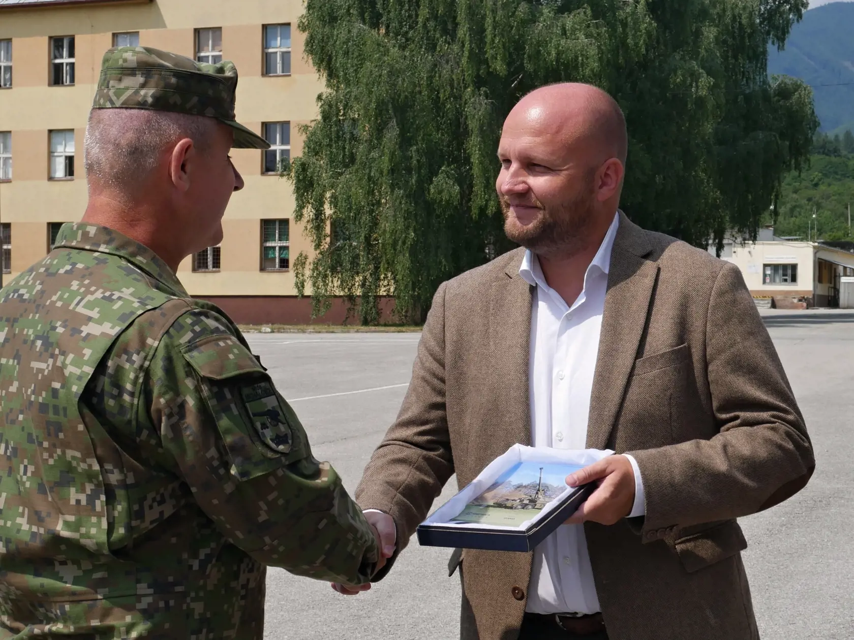 Na snímke vľavo minister obrany SR Jaroslav Naď (OĽANO) a veliteľ samohybného delostreleckého oddielu Michalovce Marek Uchaľ počas odovzdávania samohybných kanónových húfnic ZUZANA 2 do užívania profesionálnym vojakom v priestoroch 11. mechanizovaného práporu v Martine 22. júla 2021. FOTO TASR - Erika Ďurčová
