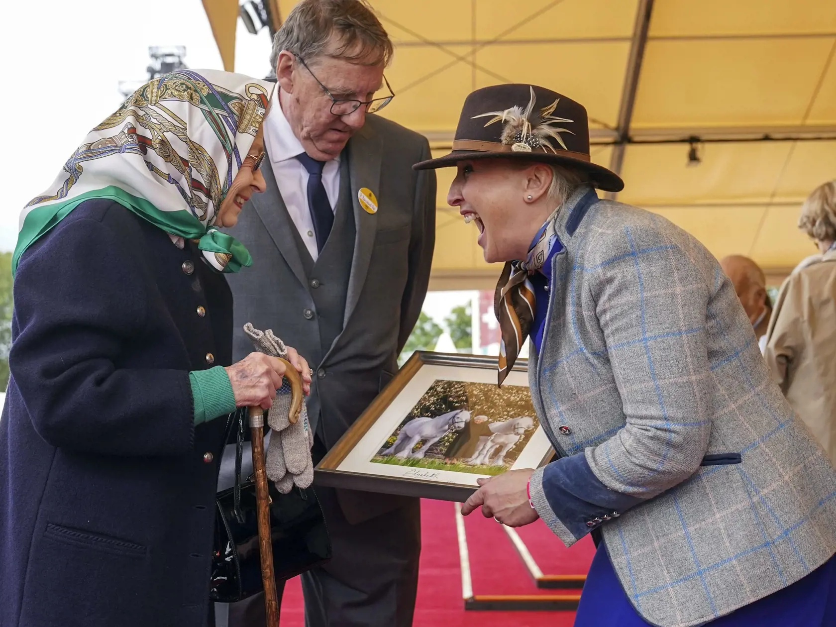 WA 34 Windsor - Deväťdesiatšesťročná britská kráľovná Alžbeta II. (vľavo) a Jane Rawdenová (vpravo) z Fell Pony Society si vymieňajú fotografie počas prehliadky koní vo Windsore v piatok 13. mája 2022. Panovníčka sa v piatok prekvapujúco objavila na verejnosti – len niekoľko dní po tom, ako ju zdravotný stav a vysoký vek prinútili prvýkrát po takmer 60 rokoch vynechať účasť na slávnostnom otvorení novej parlamentnej sezóny. FOTO TASR/AP 

Britain's Queen Elizabeth II exchanges photographs with J
