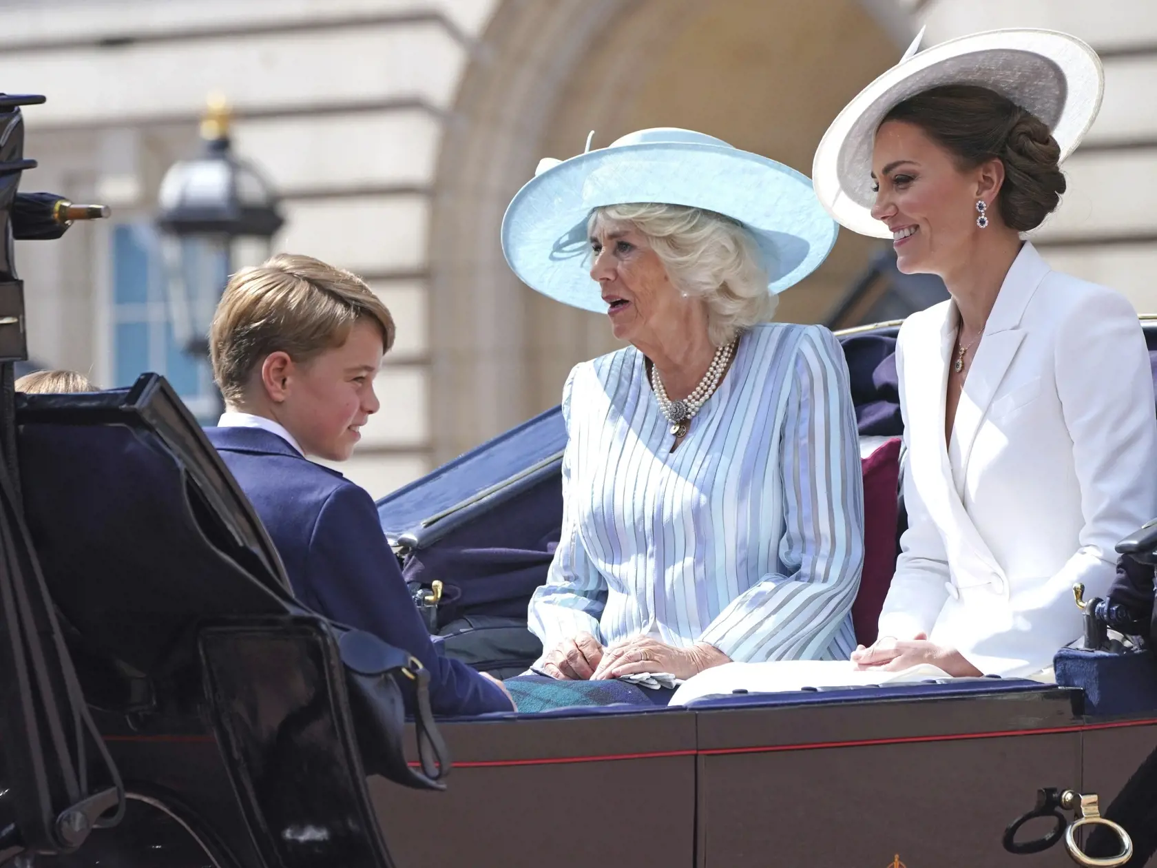 WA 43 Londýn - Na snímke zľava britský princ George; Camila, vojvodkyňa z Cornwallu a Kate, vojvodkyňa z Cambridgeu odchádzajú na koči z Buckinghamského paláca na slávnostný vojenský sprievod (Trooping the Color), ktorým sa začali štvordňové oslavy 70. výročia nástupu britskej kráľovnej Alžbety II. na trón v Londýne vo štvrtok 2. júna 2022. Kráľovná Alžbeta II. (96) oslávila 70 rokov na tróne vo februári a celonárodné oslavy jej platinového jubilea, vrátane ďakovnej bohoslužby a hudobného koncer