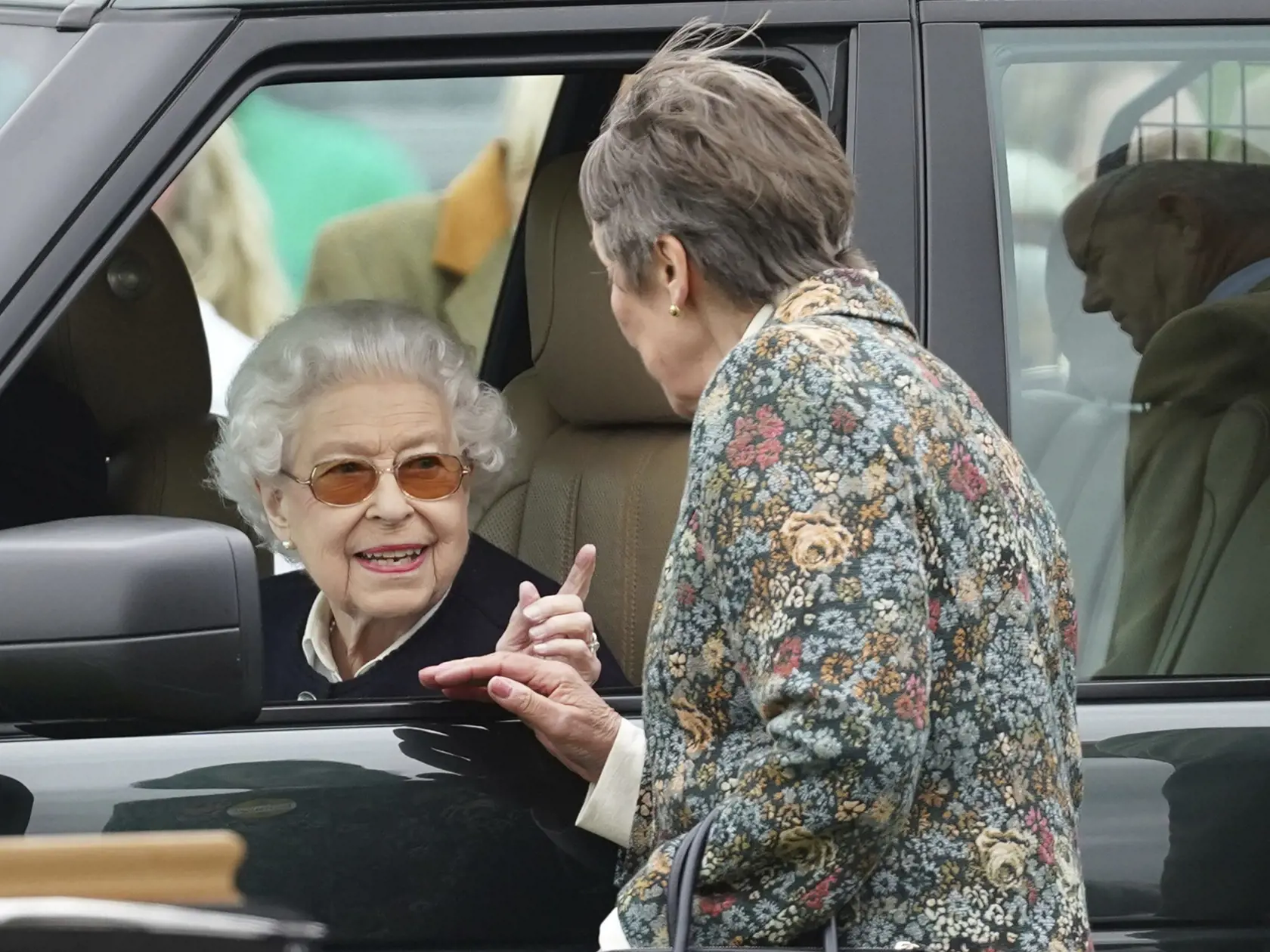WA 28 Windsor - Deväťdesiatšesťročná britská kráľovná Alžbeta II. (vľavo) sa usmieva a  konverzuje cez otvorené okno svojho Range Roveru počas príjazdu na prehliadku koní vo Windsore v piatok 13. mája 2022. Panovníčka sa v piatok prekvapujúco objavila na verejnosti – len niekoľko dní po tom, ako ju zdravotný stav a vysoký vek prinútili prvýkrát po takmer 60 rokoch vynechať účasť na slávnostnom otvorení novej parlamentnej sezóny. FOTO TASR/AP 

Britain's Queen Elizabeth II gestures during a conve