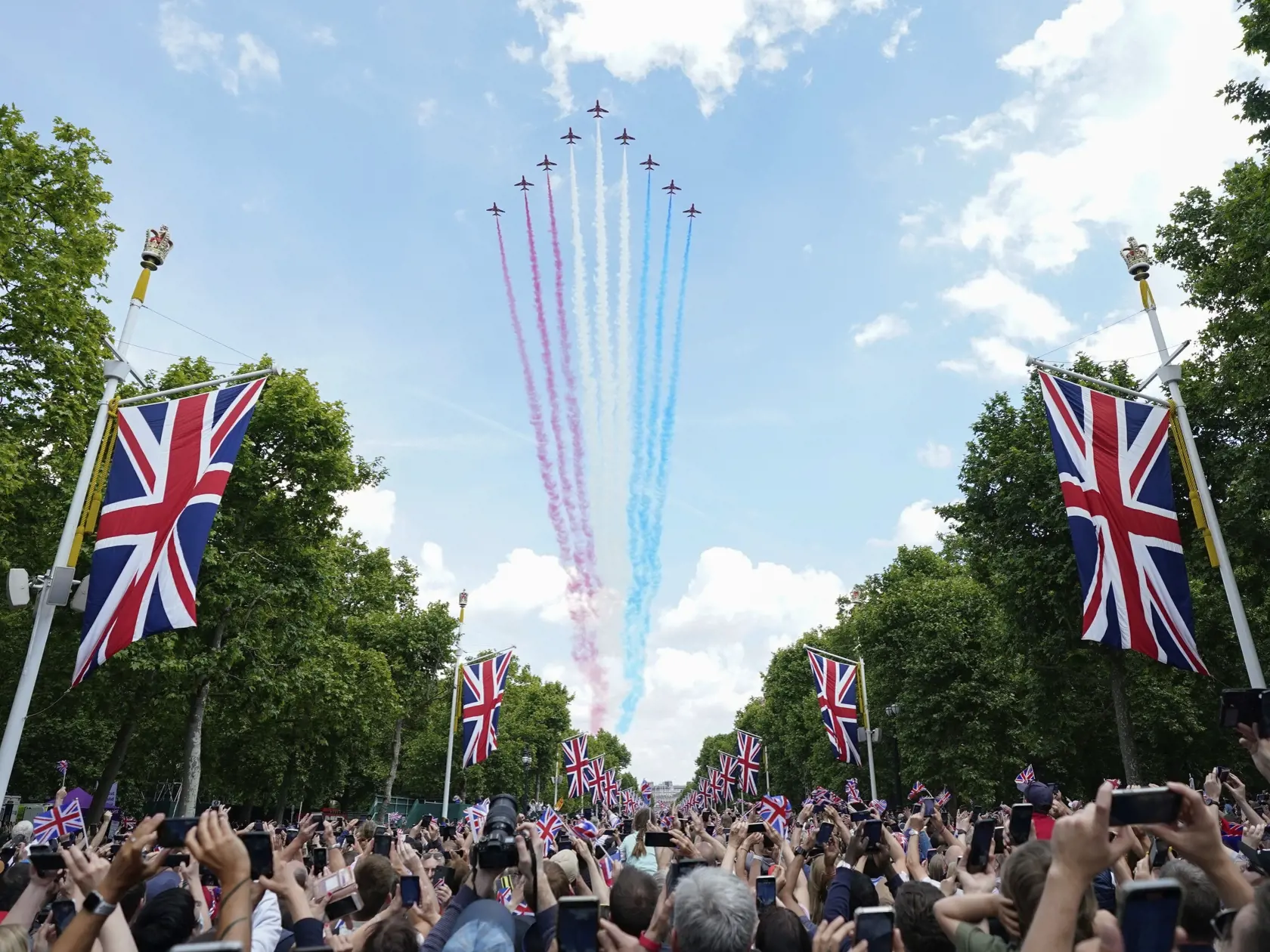 EBE 10 Londýn - Na snímke dav ľudí pred Buckinghamským palácom sleduje vystúpenie britskej leteckej akrobatickej skupiny kráľovských vzdušných síl The Red Arrows po slávnostnom vojenskom sprievode (Trooping the Color), ktorým sa začali štvordňové oslavy 70. výročia nástupu britskej kráľovnej Alžbety II. na trón v Londýne vo štvrtok 2. júna 2022. Kráľovná Alžbeta II. (96) oslávila 70 rokov na tróne vo februári a celonárodné oslavy jej platinového jubilea, vrátane ďakovnej bohoslužby a hudobného k