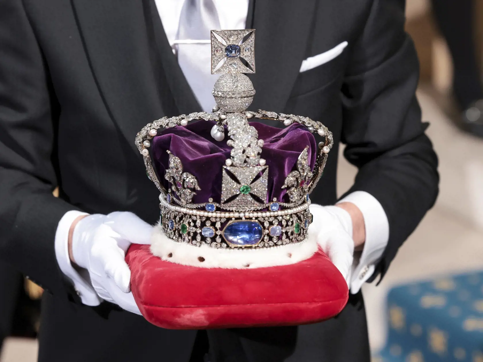 PK 6 Londýn - Strážca nesie korunu britskej kráľovnej Alžbety II. na otvorení nového zasadacieho obdobia britského parlamentu v Snemovni lordov v Londýne 10. mája 2022. Princ Charles zastúpil svoju matku kráľovnú Alžbetu II., ktorá zasadanie tradične otvára. Alžbeta II. (96) mala v poslednom období problémy s mobilitou a zrušila viacero verejných vystúpení. FOTO TASR/AP

The Imperial State Crown is carried through the Sovereign's Entrance ahead of the State Opening of Parliament at Houses of Par