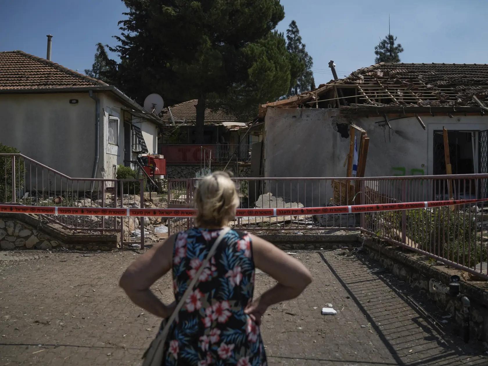 Žena sa pozerá na dom, ktorý zasiahla raketa vypálená z Libanonu neďaleko mesta Safed na severe Izraela v stredu 25. septembra 2024.