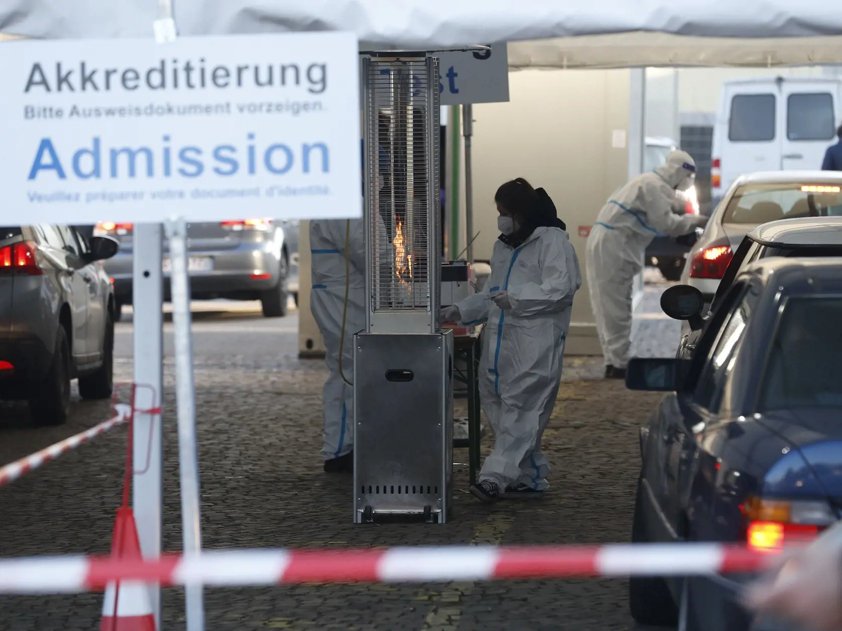 WA 33 Saarbrücken - Nemecký dobrovoľníci kontrolujú dokumenty vodičov na nemecko-francúzskom hraničnom priechode pri meste Saarbrücken, spolkovej krajine Sársko na juhozápade Nemecka v utorok 2. marca 2021.  Nemecká vláda v nedeľu 28. februára označila francúzsky departement Moselle za územie s vysokým rizikom výskytu nových variantov koronavírusu. Nemecko preto od 2. marca zaviedla prísnejšie kontroly na hraniciach s Francúzskom. FOTO TASR/AP

German help workers check documents at the German-F