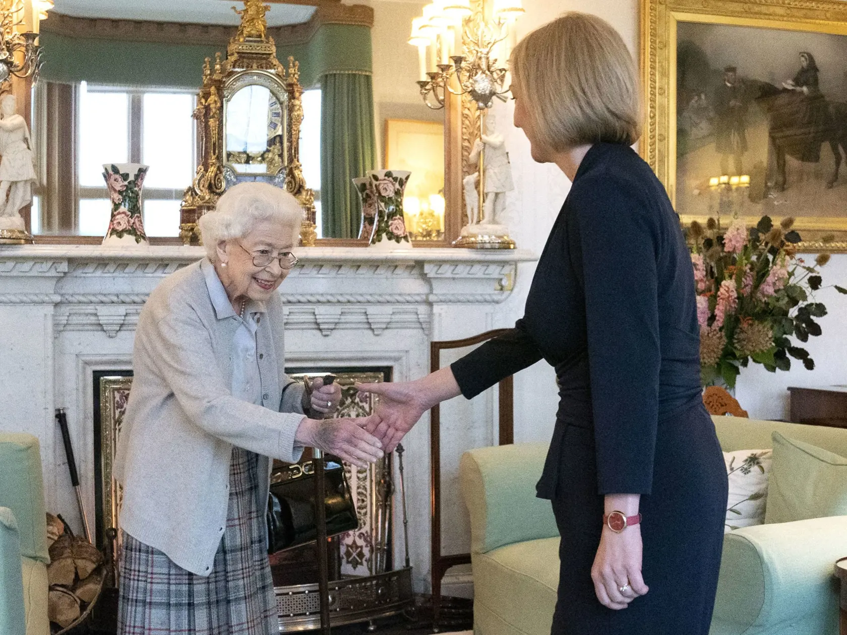 Na snímka sprava novozvolená líderka britskej Konzervatívnej strany Liz Trussová a britská kráľovná Alžbeta II. si podávajú ruky počas audiencie na zámku Balmoral, škótskeho sídla britskej kráľovnej Alžbety II. v oblasti Aberdeenshire, 6. septembra 2022.