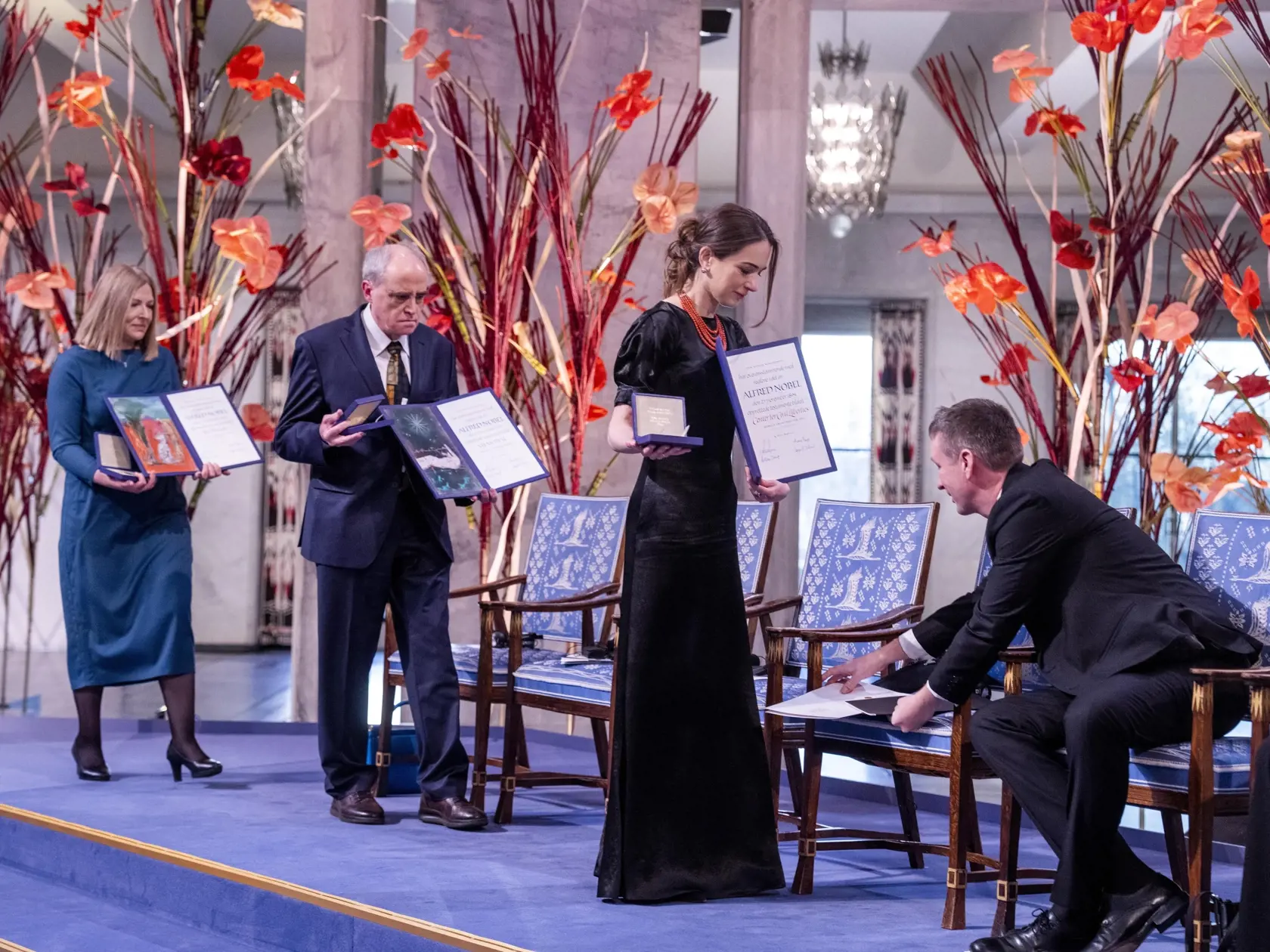 JB 67 Oslo - Druhá sprava Oleksandra Matvijčuková, riaditeľka ukrajinskej ľudskoprávnej organizácie Centrum pre občianske slobody (CCL), Jan Račinskij, predseda ruskej ľudskoprávnej organizácie Memorial a Natallia Pincjuková, manželka väzneného bieloruského aktivistu Alesa Biaľackého kráčajú s Nobelovými cenami za mier   počas slávnostného odovzdávania Nobelovej ceny za mier za rok 2022 v radnici v Osle 10. decembra 2022. Tohtoroční laureáti Nobelovej ceny za mier ohlásení v októbri, predstavujú