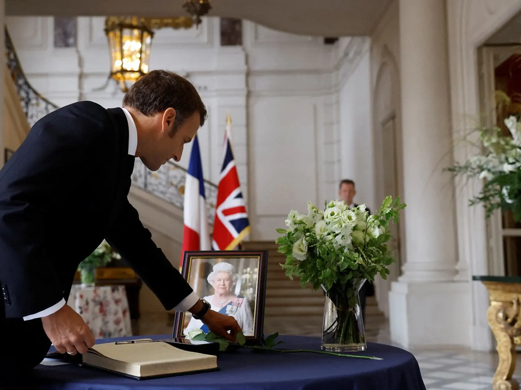 Francúzsky prezident Emmanuel Macron ukladá bielu ružu k portrétu kráľovnej Alžbety počas podpisu do kondolenčnej knihy po úmrtí britskej kráľovnej Alžbety II. na britskom veľvyslanectve v Paríži, Francúzsko, 9. septembra 2022.