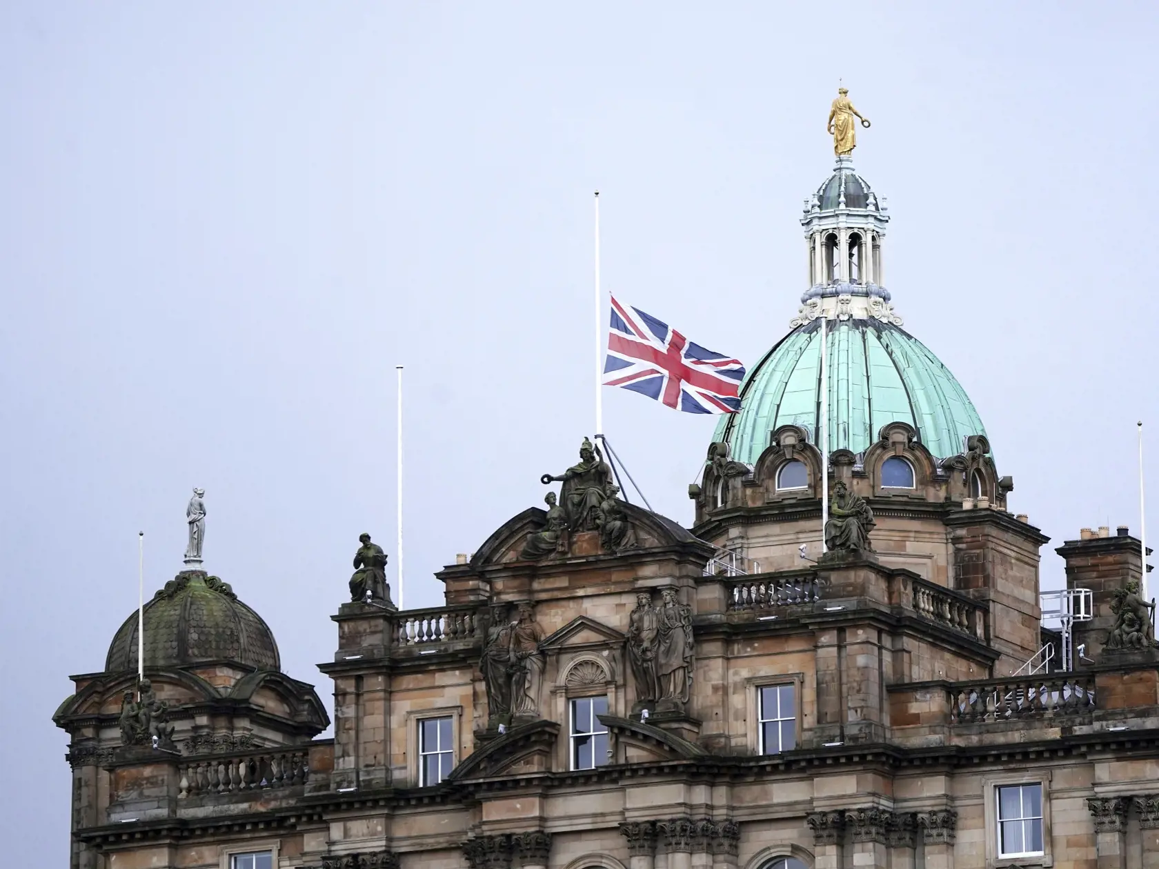 JB 33 Edinburgh - Britská zástava stiahnutá na pol žrde na budove Banky Škótska v škótskom Edinburghu 9. septembra 2022. Na oficiálnej webovej stránke britskej kráľovskej rodiny bola zriadená virtuálna kondolenčná kniha na pamiatku zosnulej britskej kráľovnej Alžbety II. Agentúra TASR o tom informuje na základe správy britskej stanice BBC. Kráľovná Alžbeta II zomrela vo štvrtok popoludní vo svojom škótskom sídle Balmoral. Bola najdlhšie vládnucim monarchom v dejinách Británie – na tróne bola 70 
