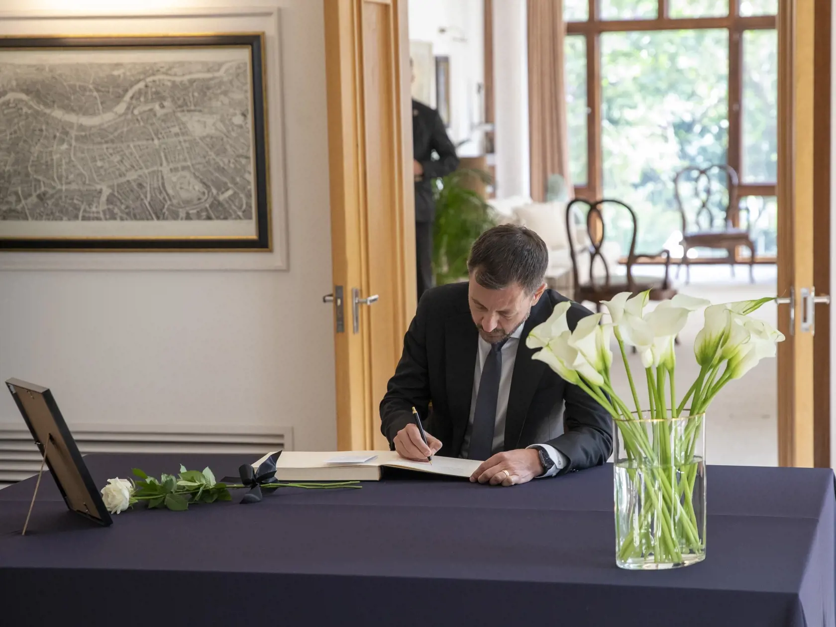 Na snímke je premiér Eduard Heger na britskej ambasáde v Bratislave pri zápise do kondolenčnej knihy .
