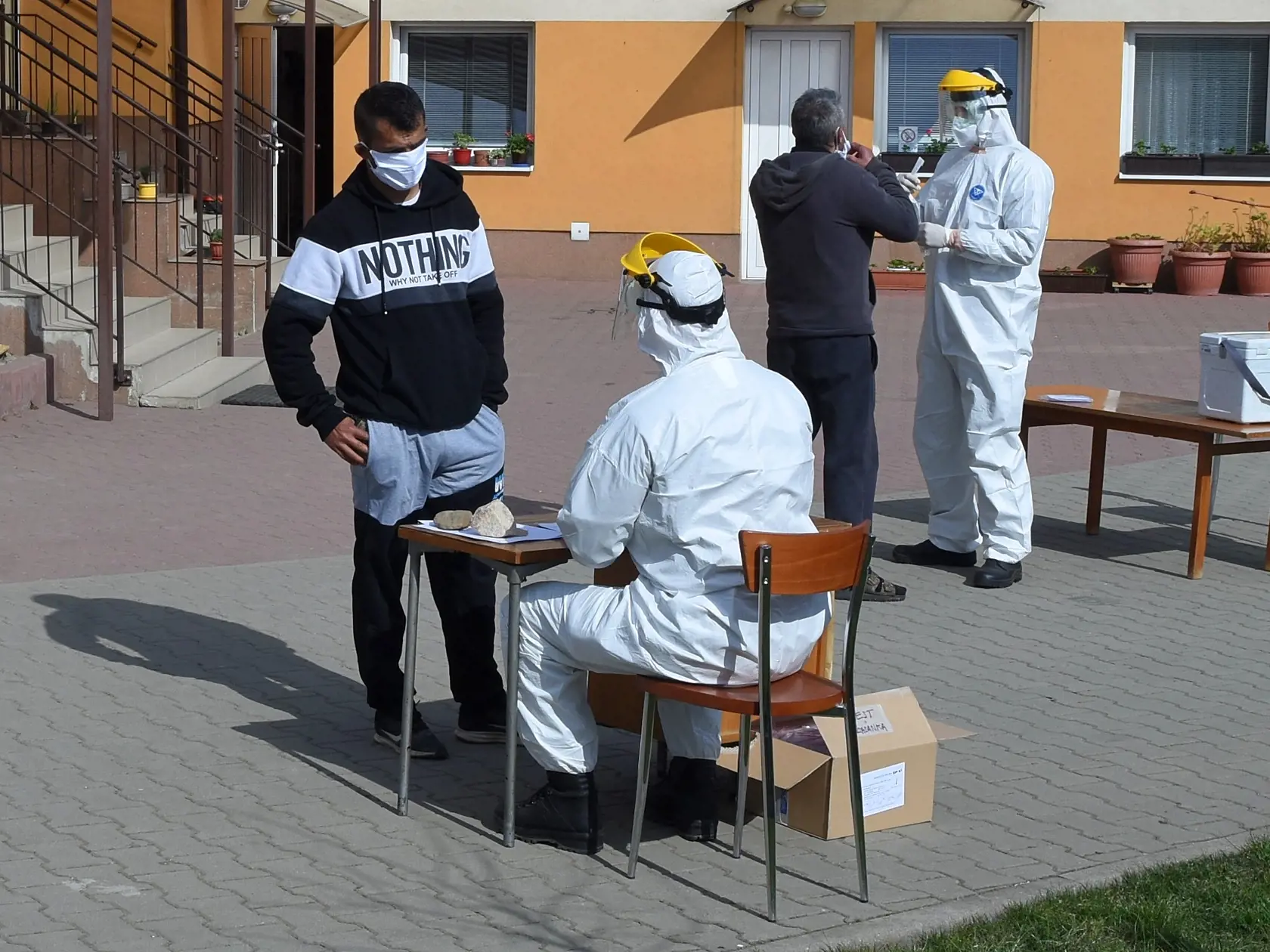 Na snímke príslušníci Ozbrojených síl SR odoberajú klinické vzorky počas testovania rómskych obyvateľov pred pastoračným centrom v obci Lomnička, okres Stará Ľubovňa v rámci preventívnych opatrení k zamedzeniu šírenia koronavírusu v piatok 10. apríla 2020. FOTO TASR - Oliver Ondráš