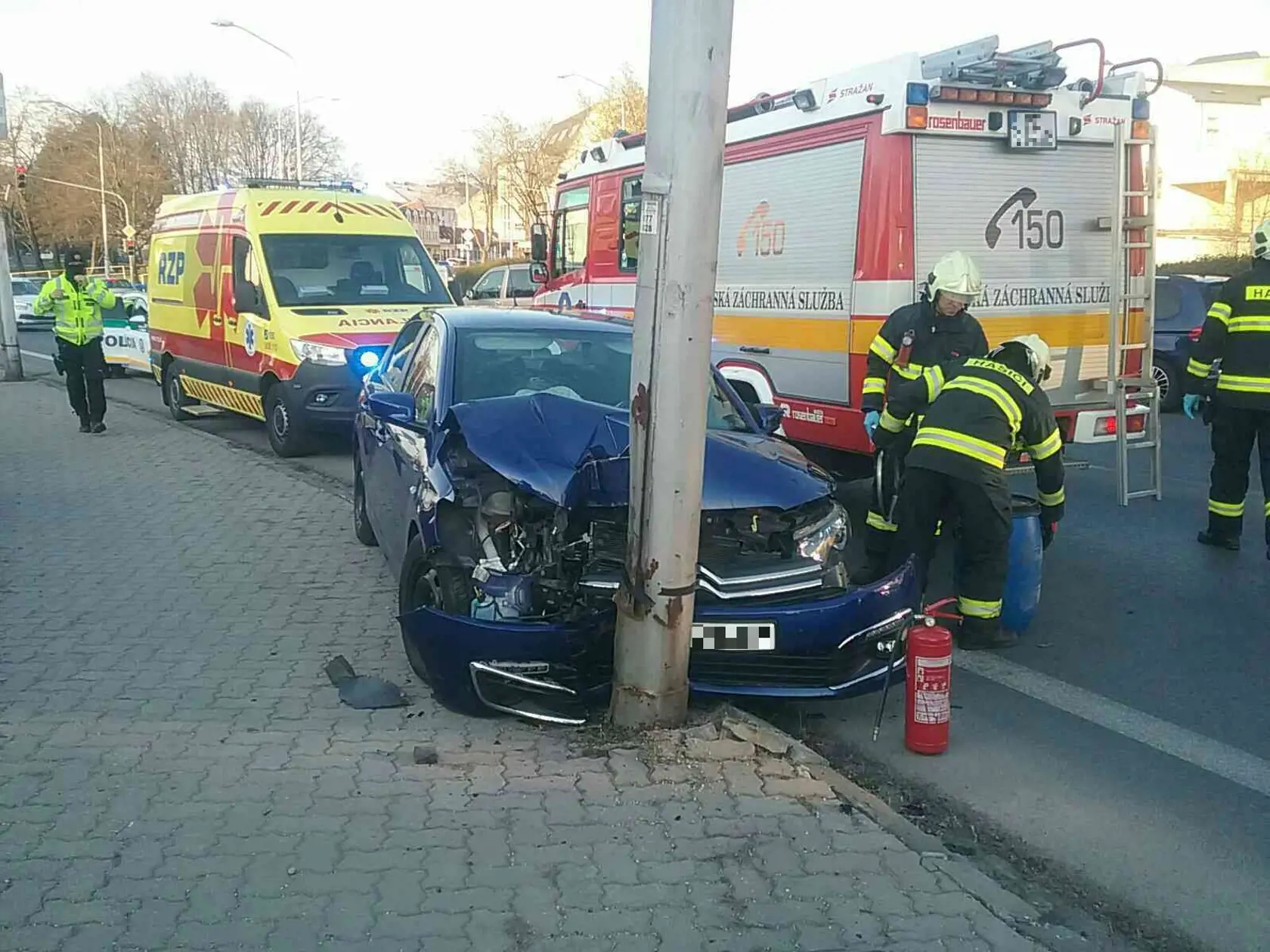 Hasiči zasahujú po náraze osobného auta do stĺpa verejného osvetlenia, ku ktorému došlo na nájazde na cestný most v Trenčíne v stredu podvečer 5. apríla 2023. FOTO TASR - HaZZ v Trenčíne