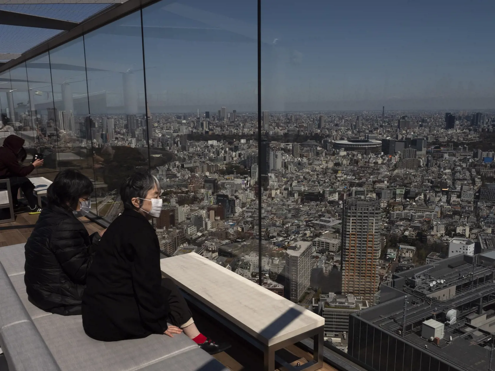 MIK 1 Tokio - Návštevníci si prezerajú panorámu Tokia z vyhliadkovej plošiny v Tokiu 25. marca 2020. Japonské hlavné mesto Tokio sa stalo epicentrom nákazy koronavírusu SARS-CoV-2 v krajine. Za jediný deň zaznamenalo rekordne vysoký počet nových prípadov. Medzinárodný olympijský výbor (MOV) v utorok oficiálne rozhodol o odložení olympijských hier v Tokiu na rok 2021. Dôvod je pandémia nového koronavírusu.

Vistors view Tokyo's skyline from an observation deck Wednesday, March 25, 2020, in Tokyo.