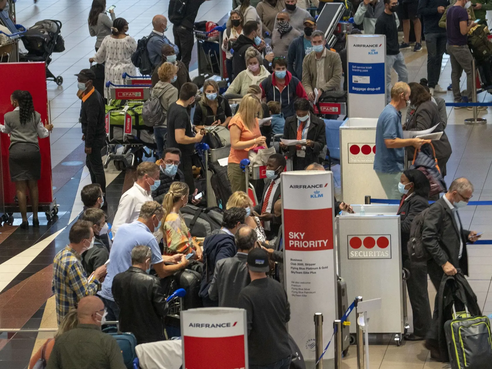 Cestujúci stoja v rade na let spoločnosti Air France do Paríža na medzinárodnom letisku v Johannesburgu.