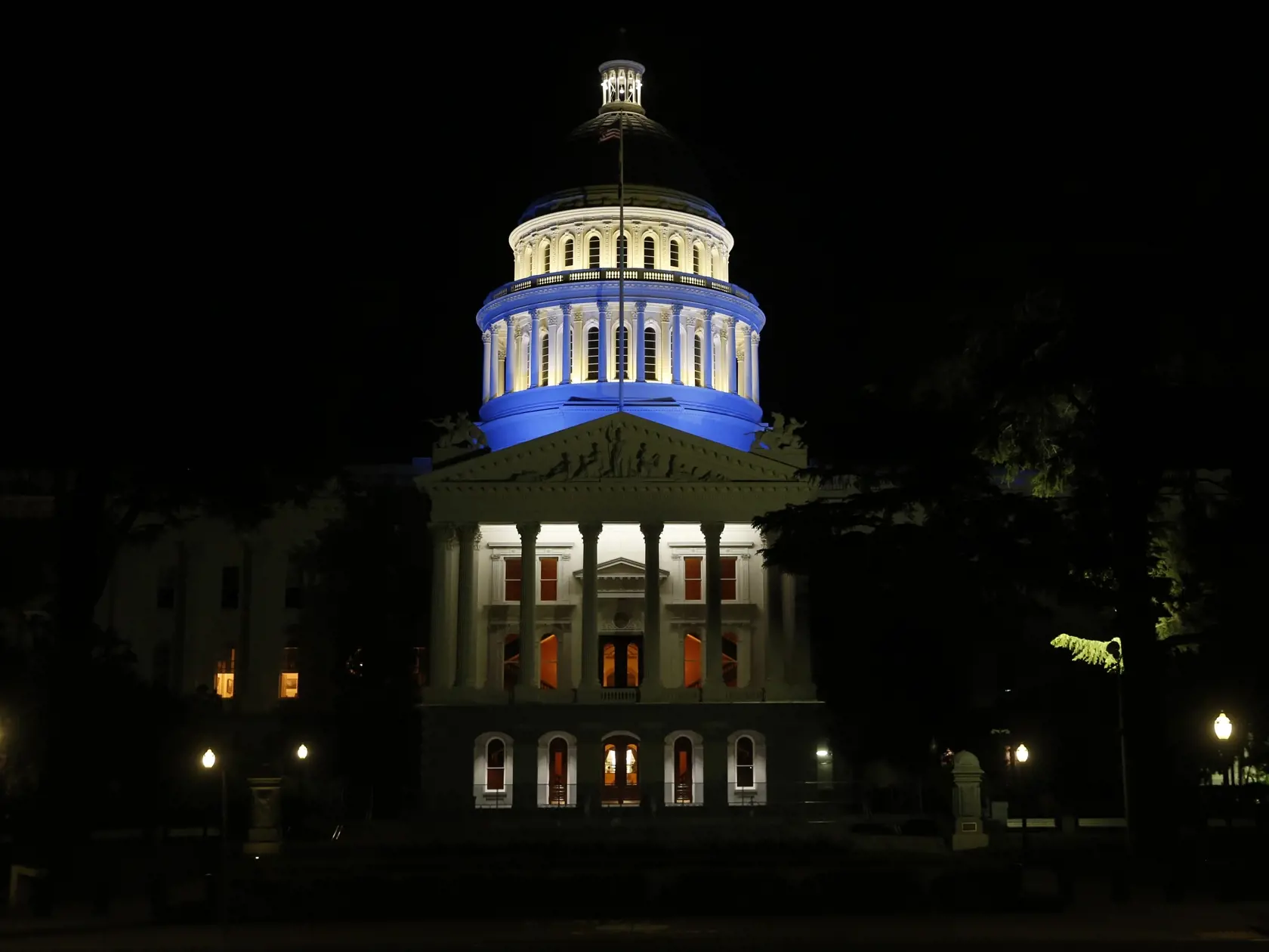 Na snímke budova múzea histórie a sídla vlády štátu Kalifornia v meste Sacramento vysvietená namodro na podporu zdravotného personálu a ďalších pracovníkov, ktorí bojujú v prvej línii proti novému typu koronavírusu v noci na štvrtok 16. apríla 2020. FOTO TASR/AP