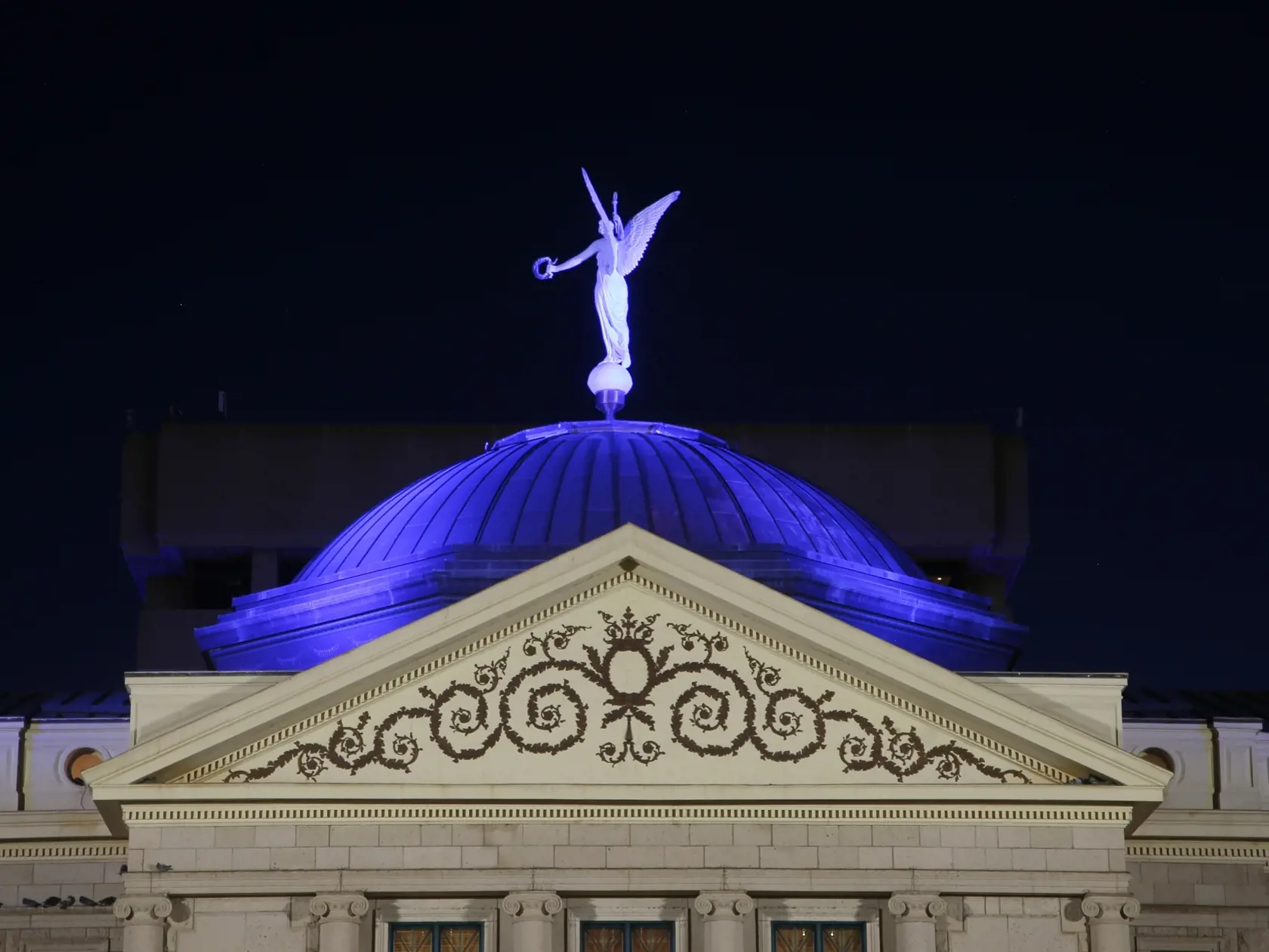 EBE 7 Phoenix - Na snímke kupola budovy múzea Arizona Capitol Museum v americkom Phoenixe je vysvietená namodro podobne ako ostatné štátne budovy na podporu zdravotného personálu a ďalších pracovníkov, ktorí bojujú v prvej línii proti novému typu koronavírusu v noci na štvrtok 16. apríla 2020. FOTO TASR/AP
The dome of the Arizona Capitol building is illuminated in blue as buildings and structures around the state are lit in blue as a symbol of support for Arizona's frontline medical workers and 