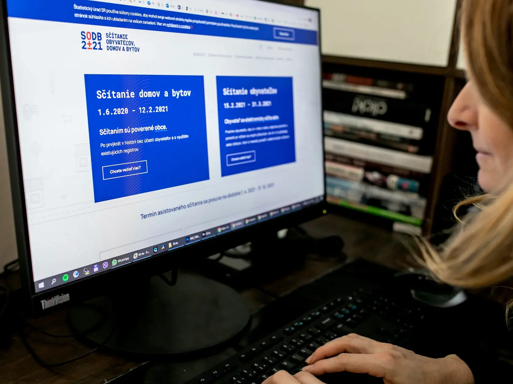 Na snímke je žena ako si na počítači pozerá web stránku o sčítaní domov a bytov.