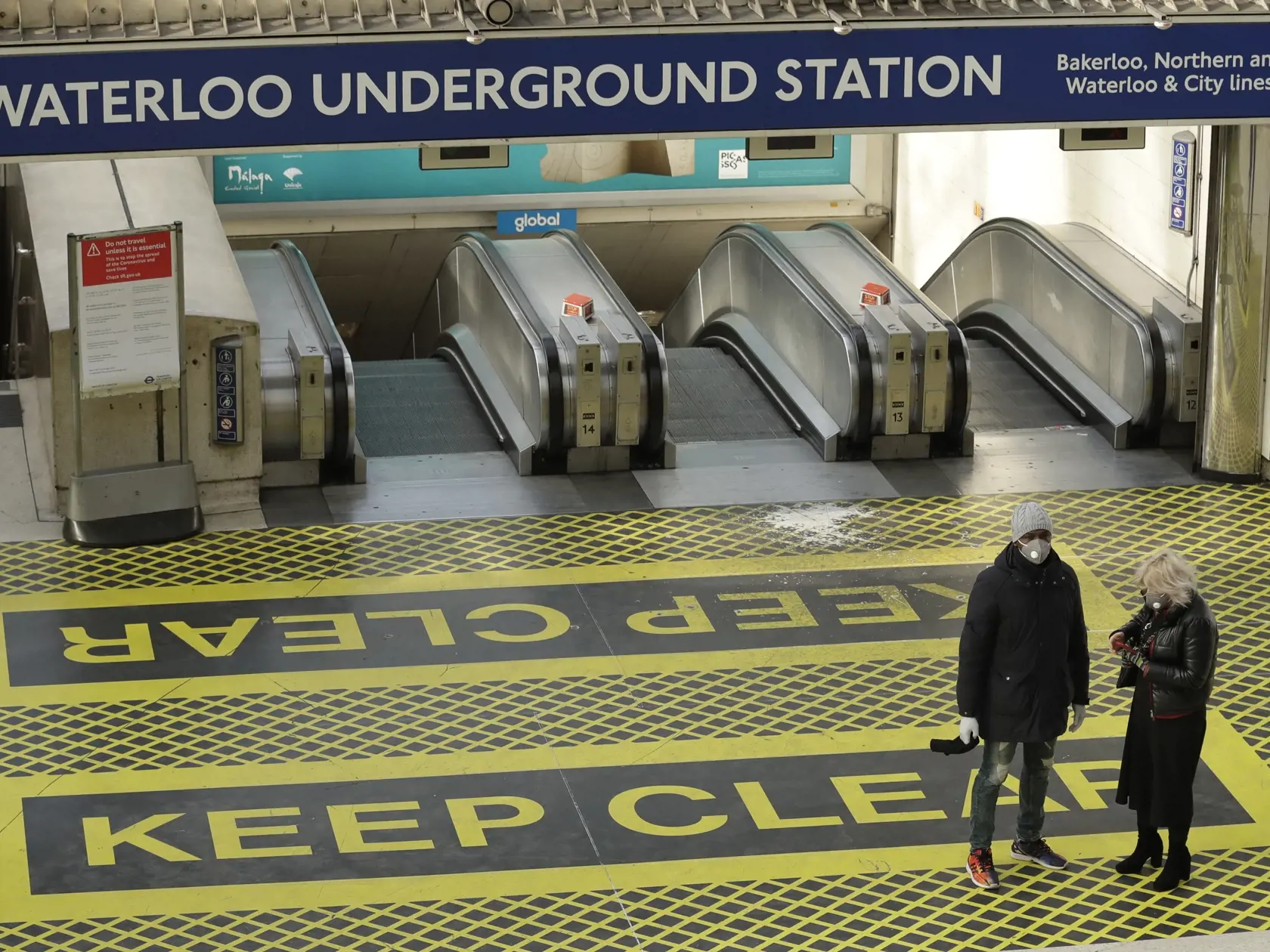 MIK 14 Londýn -  Dvaja ľudia s ochrannými rúškami stoja pri pohyblivých schodoch na stanici metra Waterloo v Londýne 24. marca 2020. Počet úmrtí na nový koronavírus stúpol v Británii v pondelok, teda za jediný deň, o 54. Celkovo tak v tejto ostrovnej krajine evidujú už 335 obetí na životoch. Premiér Boris Johnson zvažuje zavedenie prísnejších opatrení na spomalenia šírenia vírusu, keďže tisíce ľudí v Británii ignorujú príslušné odporúčania vlády. FOTO TASR/AP

Two people waring masks stand at th