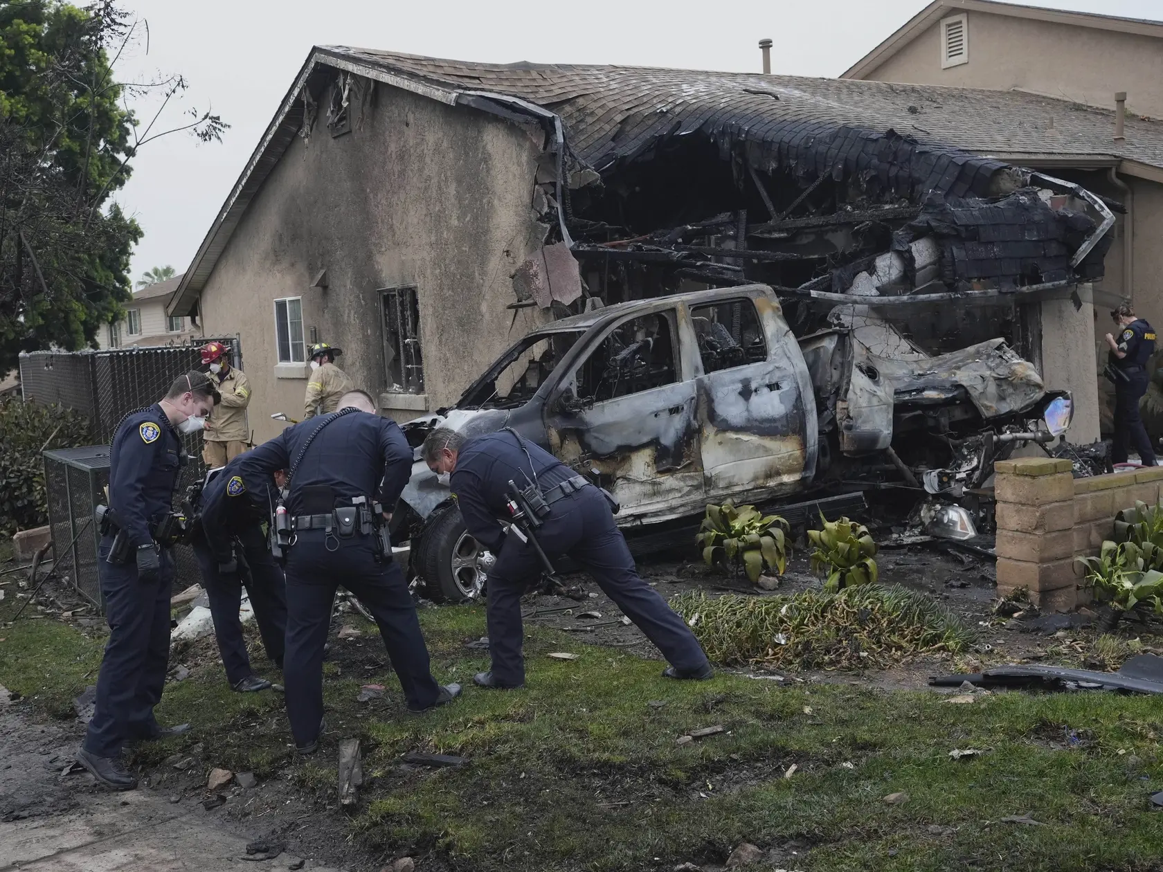WA 11 San Diego - Príslušníci záchranných zložiek zasahujú po páde malého súkromného lietadla v obytnej zóne v meste San Diego v americkom štáte Kalifornia vo štvrtok 22. mája 2025. Pri páde poškodilo viaceré domy a úrady nariadili evakuáciu. Podľa úradov mohol pád zasiahnuť až 15 domov, presný rozsah škôd doposiaľ nebol známy. FOTO TASR/AP
Authorities work the scene where a small plane crashed into a San Diego neighborhood, setting several homes on fire and forcing evacuations along several blocks early Thursday, May 22, 2025. (AP Photo/Gregory Bull)