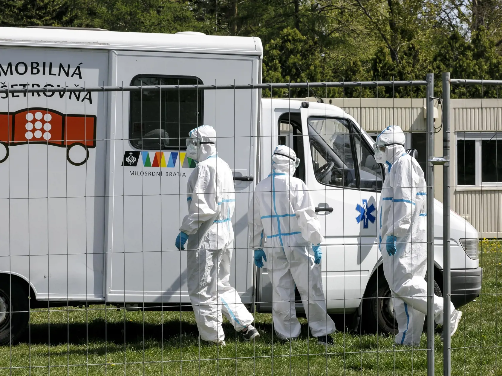 Na snímke sociálni pracovníci v ochranných odevoch počas otvorenia kontajnerového mestečka pre ľudí bez domova v areáli Zlatých pieskov v Bratislave 16. apríla 2020. FOTO TASR - Dano Veselský