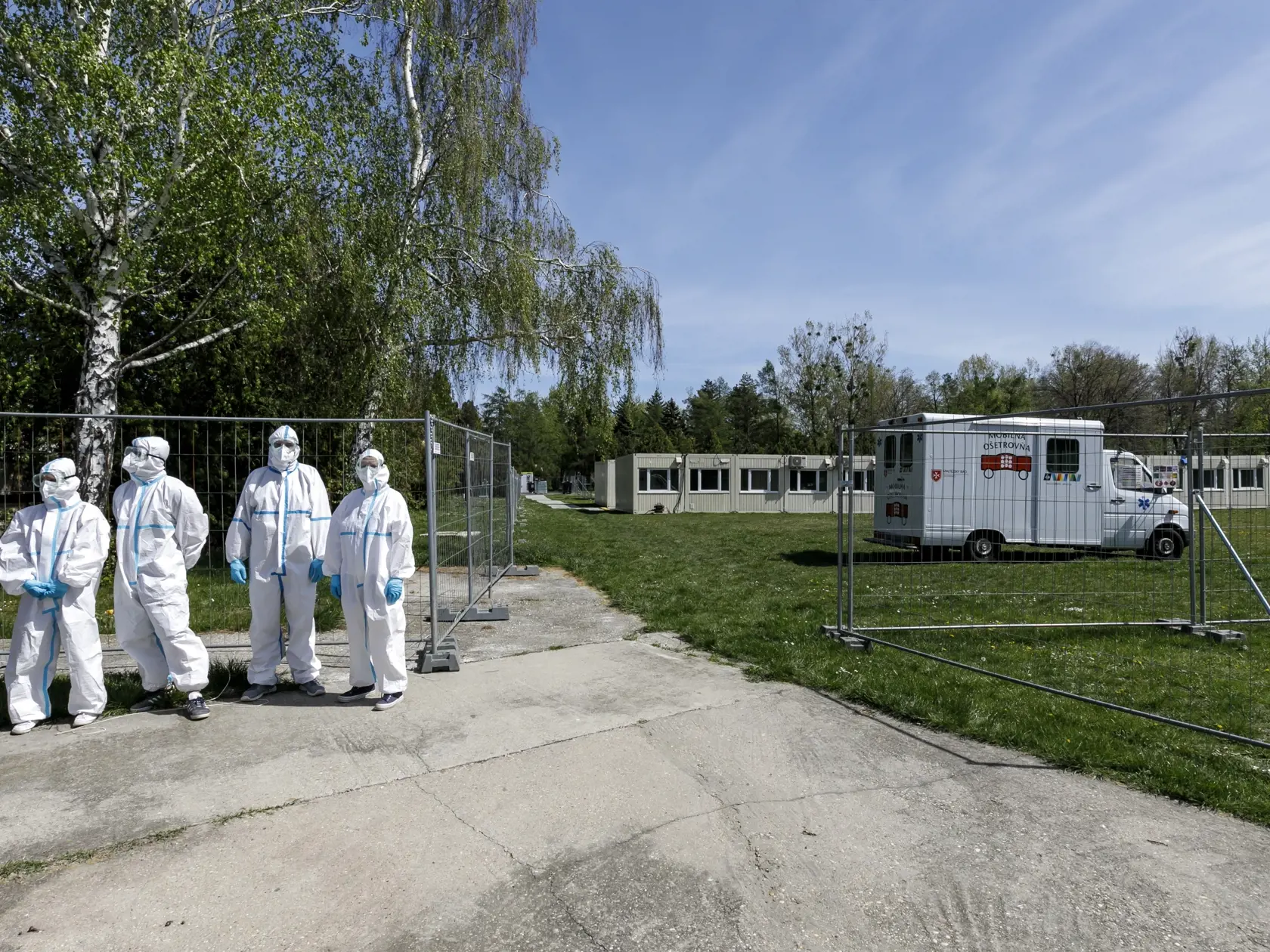 Na snímke sociálni pracovníci v ochranných odevoch počas otvorenia kontajnerového mestečka pre ľudí bez domova v areáli Zlatých pieskov v Bratislave 16. apríla 2020. FOTO TASR - Dano Veselský