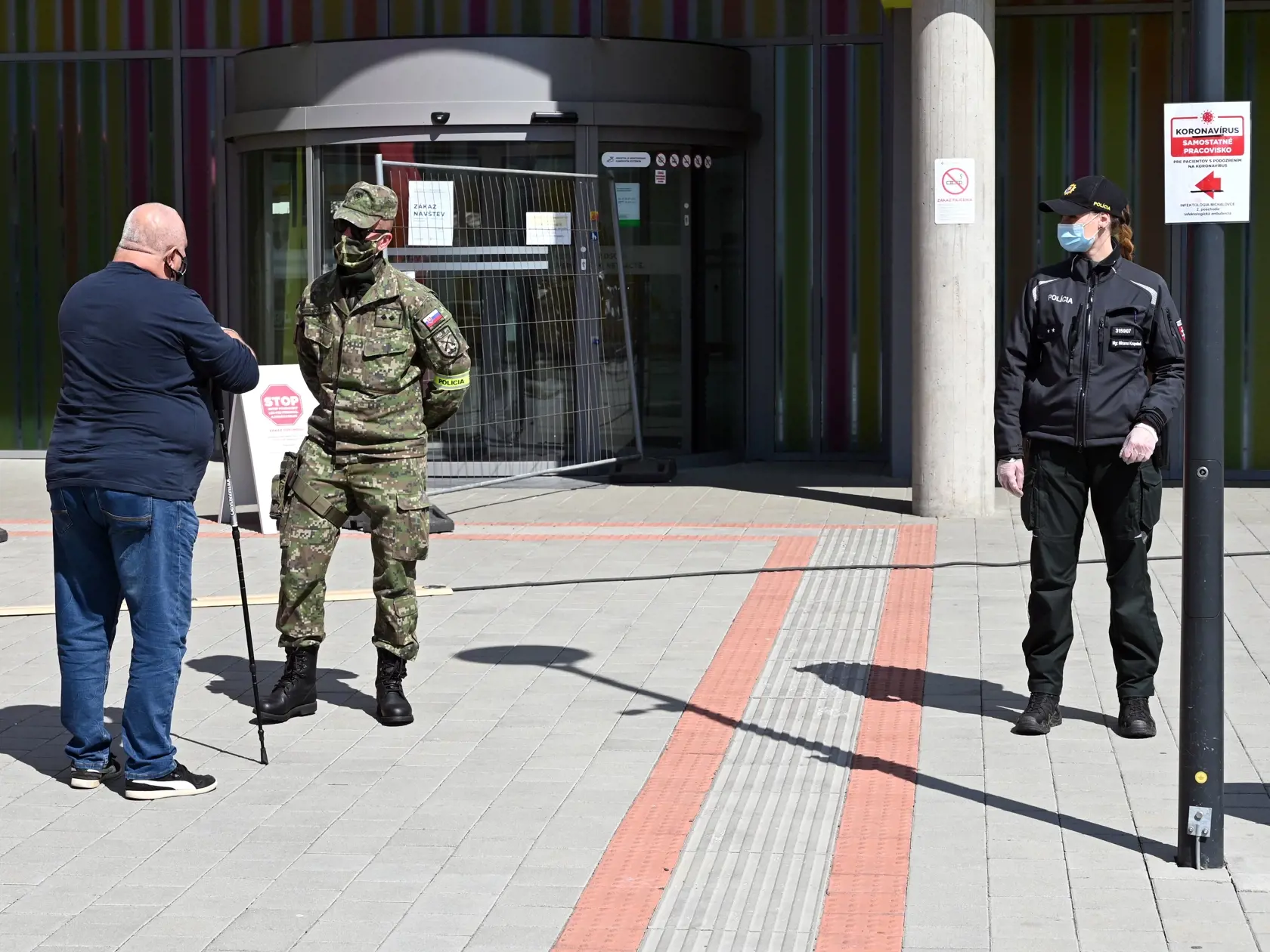 Traja zdravotníci pracujúci na rádiologickom oddelení (RTG) v Nemocnici s poliklinikou Štefana Kukuru v Michalovciach boli pozitívne testovaní na nový koronavírus. Na snímke policajtka a vojak pred Nemocnicou s poliklinikou Štefana Kukuru v Michalovciach 16. apríla 2020. FOTO TASR - Roman Hanc