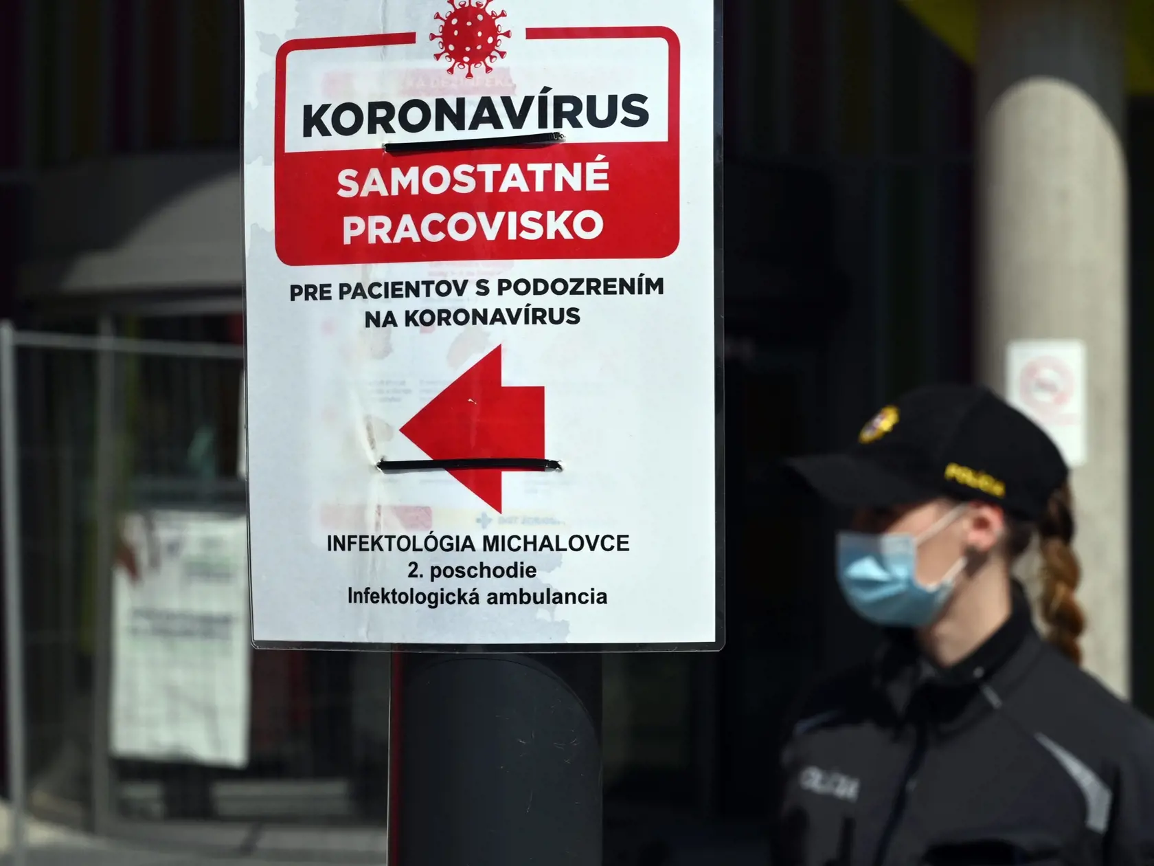Traja zdravotníci pracujúci na rádiologickom oddelení (RTG) v Nemocnici s poliklinikou Štefana Kukuru v Michalovciach boli pozitívne testovaní na nový koronavírus. Na snímke policajtka pred Nemocnicou s poliklinikou Štefana Kukuru v Michalovciach 16. apríla 2020. FOTO TASR - Roman Hanc