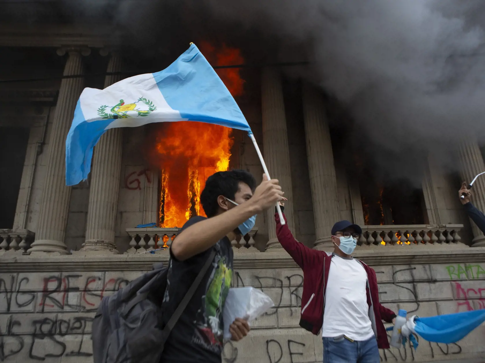 EBE 13 Guatemala - Stovky protestujúcich v Guatemale sa v sobotu vlámali do budovy miestneho Kongresu a založili v nej požiar. Na snímke demonštrant máva štátnou vlajkou pred horiacou budovou Kongresu v sobotu 21. novembra 2020. FOTO TASR/AP
A protester waves a national flag as a part of the Congress building burns in the background, set on fire by protesters, in Guatemala City, Saturday, Nov. 21, 2020. Hundreds of protesters were protesting in various parts of the country Saturday against Guate