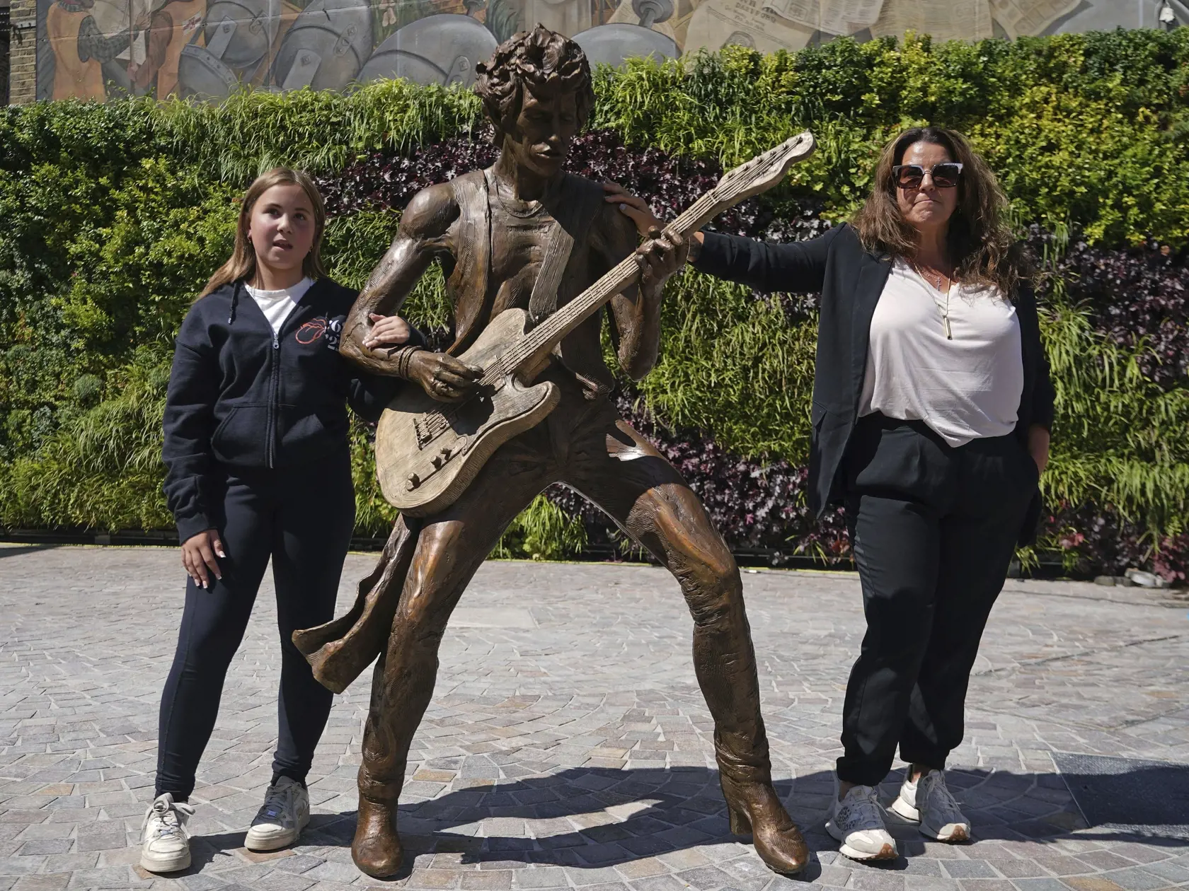 WA 53 Dartforf - Angela, dcéra Keitha Richardsa a jeho 12-ročná vnučka Ava pózujú pri 
bronzovom súsoší dvojice protagonistov rockovej skupiny The Rolling Stones - Micka Jaggera a Keitha Richardsa -, ktoré  odhalili na ulici High Street v anglickom meste Dartford v stredu 9. augusta 2023. Dielo si objednala mestská rada a bolo financované z príspevku na verejné umenie, ktorý poskytla spoločnosť Bellway London's Copperhouse Green Development, informuje webová stránka Kent Online. Jagger (80) i Ri