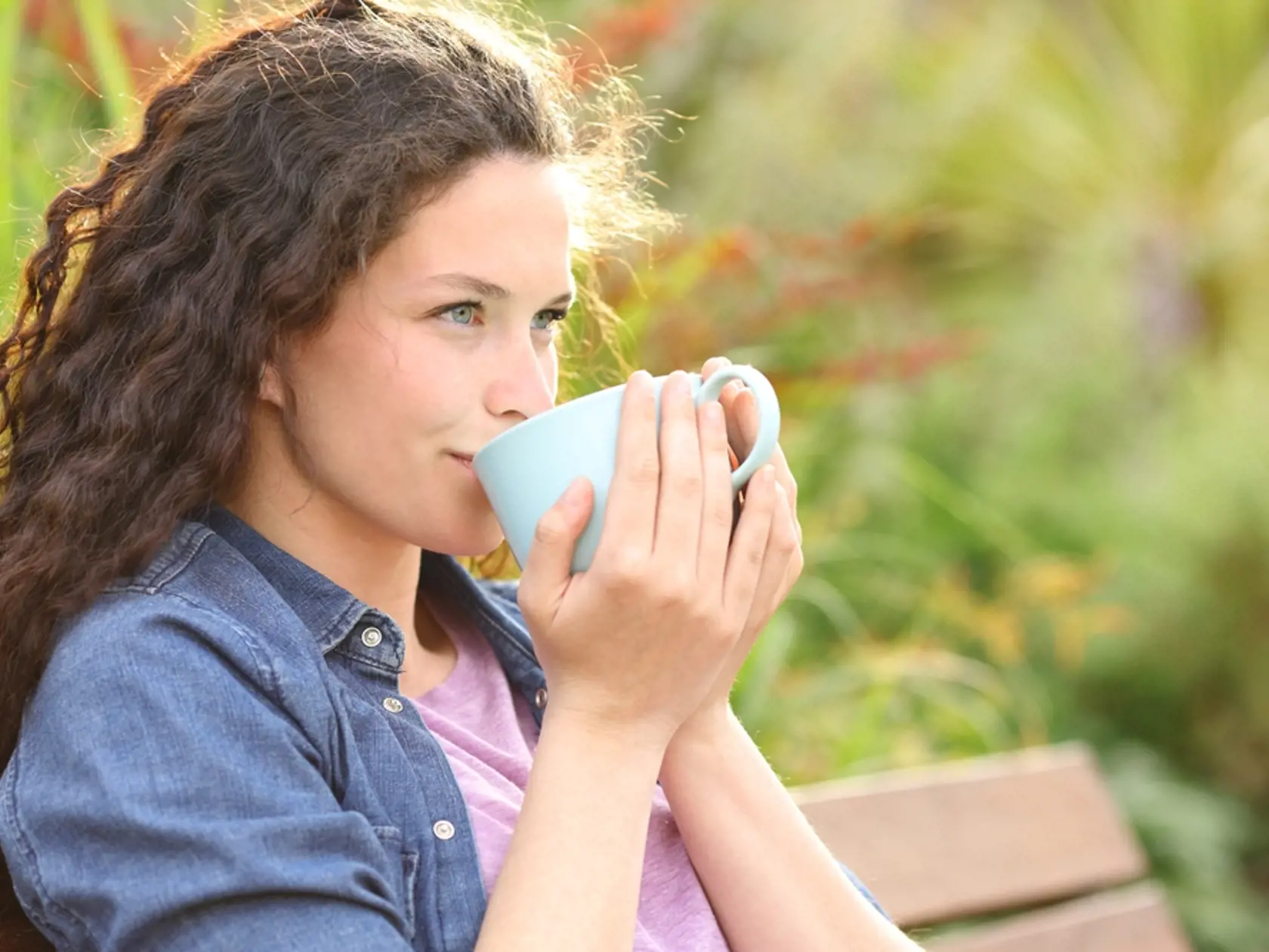 Confident,Woman,Drinking,Coffee,Looking,Away,Sitting,In,A,Bench