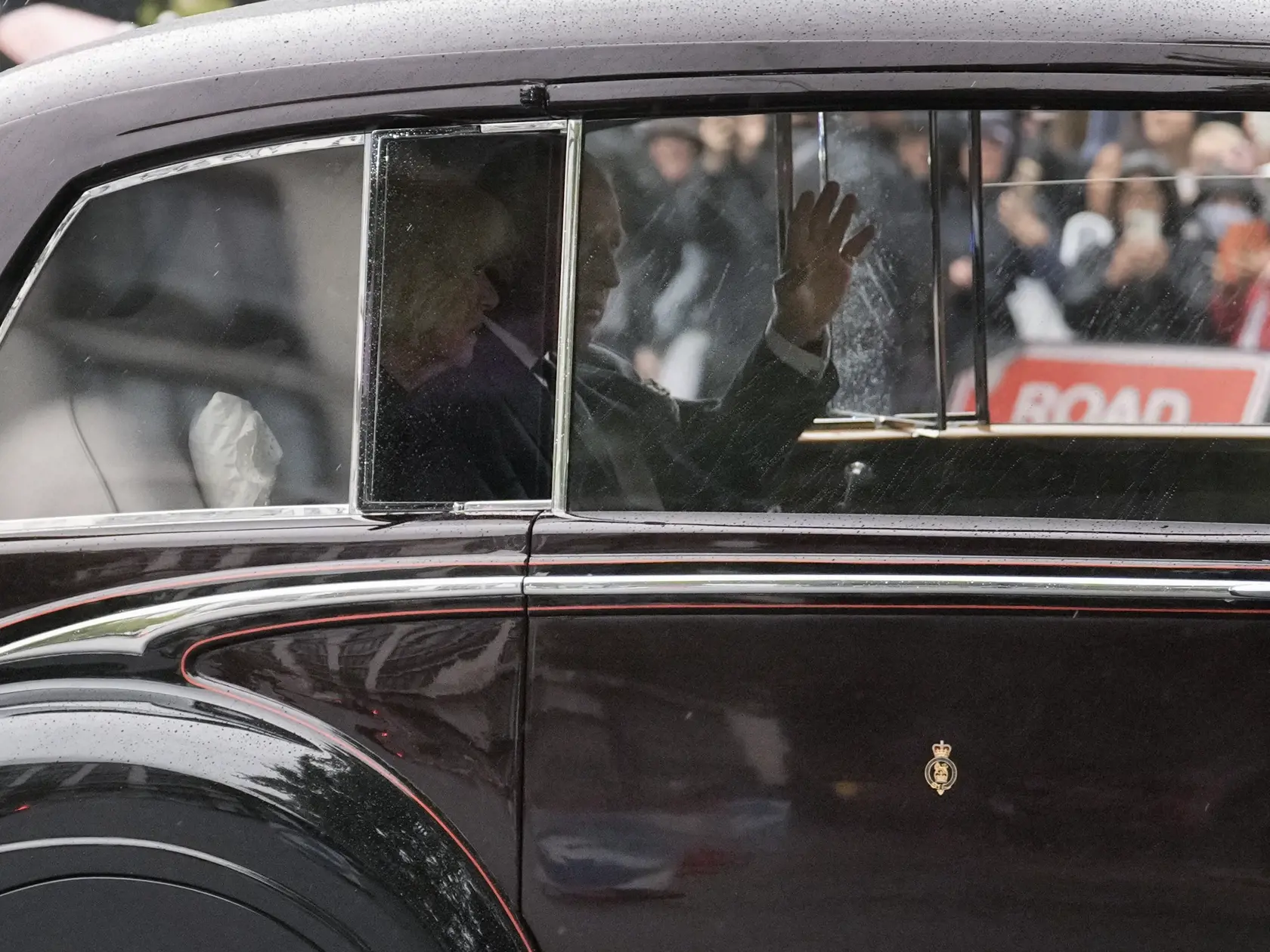 Britský kráľ Charles III. a Camilla, kráľovná manželka mávajú ľuďom z auta počas ich príchodu do Buckinghamského paláca 13. septembra 2022. Rakvu zosnulej britskej kráľovnej Alžbety II. previezli dnes letecky zo Škótska do Londýna. Kráľovná Alžbeta II. zomrela vo štvrtok 8. seprembra popoludní vo svojom škótskom sídle Balmoral. Bola najdlhšie vládnucim monarchom v dejinách Británie – na tróne bola 70 rokov. FOTO TASR/AP