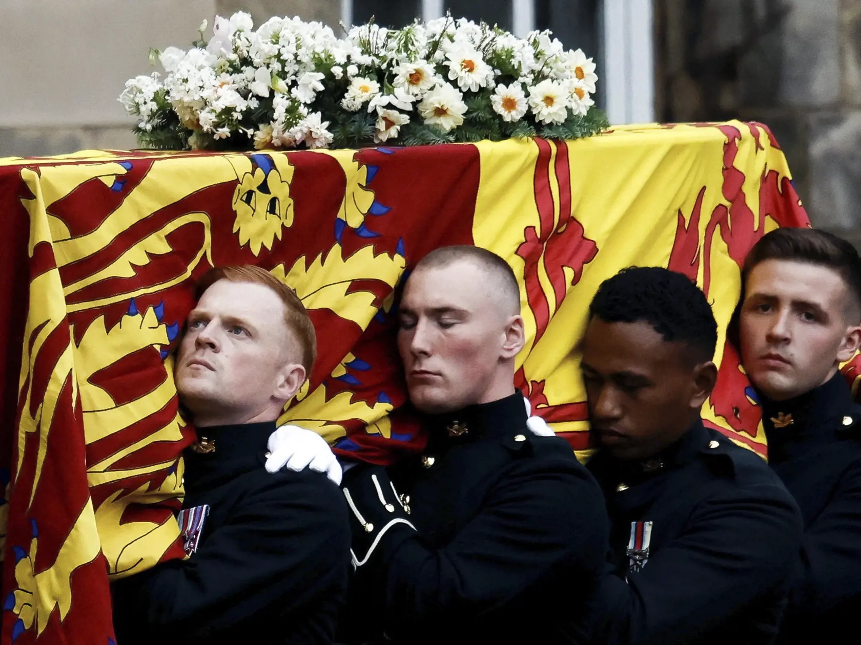PK 103 Edinburgh - Na snímke nosiči rakvy s pozostatkami zosnulej britskej kráľovnej Alžbety II. ju nesú do zámku Holyrood v Edinburghu 11. septembra 2022. Rakva s pozostatkami zosnulej britskej kráľovnej Alžbety II. v nedeľu dorazila na zámok Holyrood v Edinburghu, ktorý je oficiálnym sídlom britského panovníka v Škótsku. Od štvrtka sa rakva nachádzala na Balmorale, kde sa s kráľovnou mohli rozlúčiť jej najbližší príbuzní. FOTO TASR/AP

Pallbearers carry the coffin of Queen Elizabeth II, draped