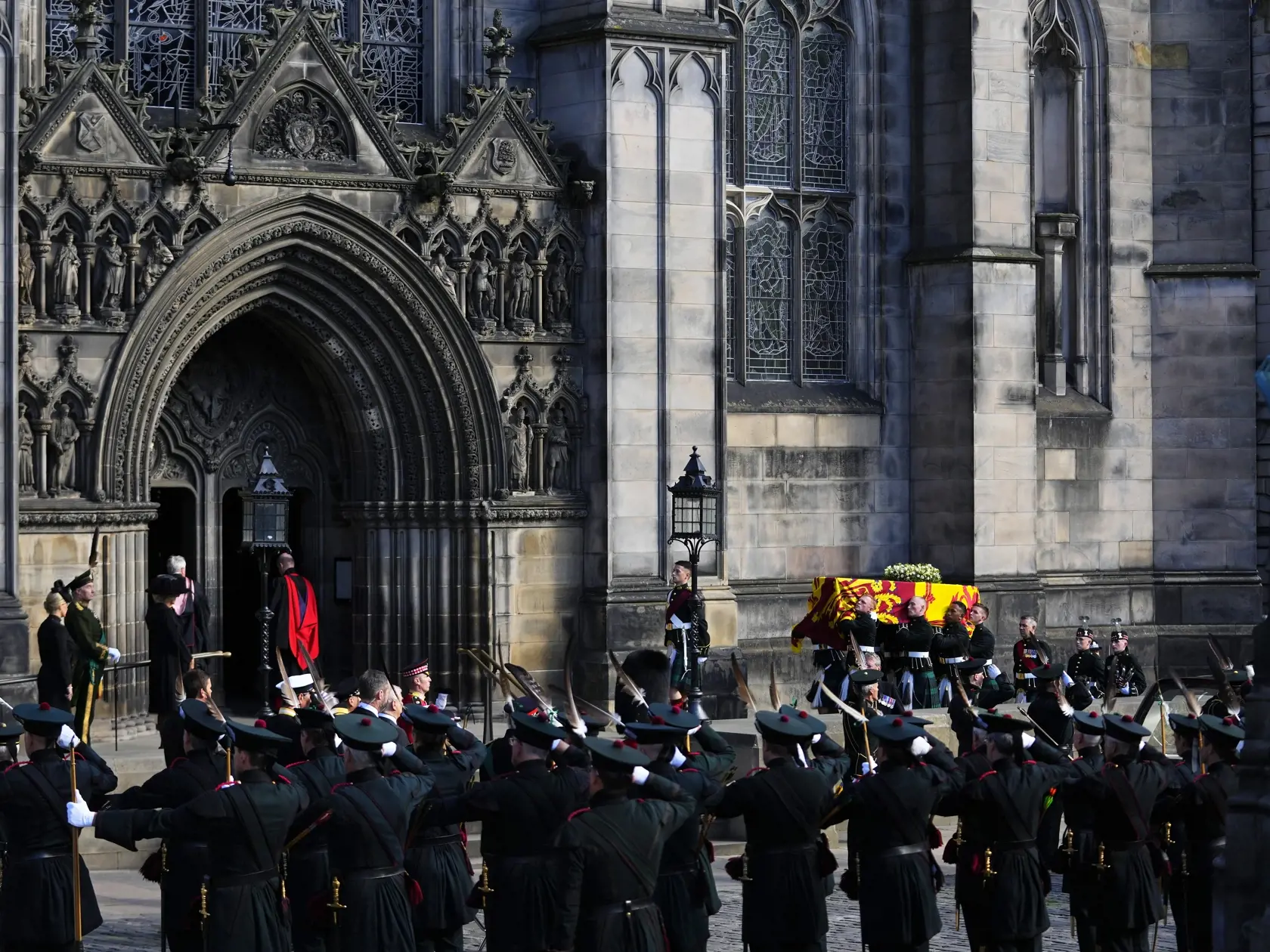 WA 68 Edinburgh - Príslušníci Kráľovskej spoločnosti lukostrelcov stoja v pozore, keď rakva s pozostatkami britskej kráľovnej Alžbety II. smeruje do Katedrály svätého Egídia v škótskom Edinburghu v pondelok 12. septembra 2022. Rakva so zosnulou kráľovnou bude v Edinburghu vystavená na 24 hodín so štátnymi poctami. V utorok ju majú previezť do Londýna. Alžbeta II. zomrela vo štvrtok 8. septembra vo veku 96 rokov. Vládla od roku 1952. Pohreb sa uskutoční 19. septembra vo Westminsterskom opátstve v