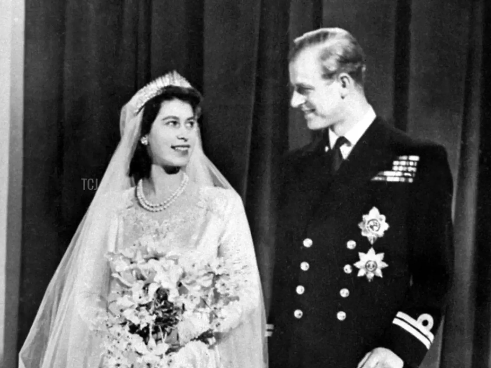 Zlomený diadém

Princezná Alžbeta mala počas sobáša na hlave diadém Queen Mary's Fringe Tiara, zapožičaný od jej matky. Ráno pred svadbou sa však diadém nešťastne zlomil, a tak ho musel narýchlo opravovať zlatník. Klenotník zlomenie rýchlo napravil, no po unáhlenej oprave zostala v strede rámu trochu viditeľná medzera.