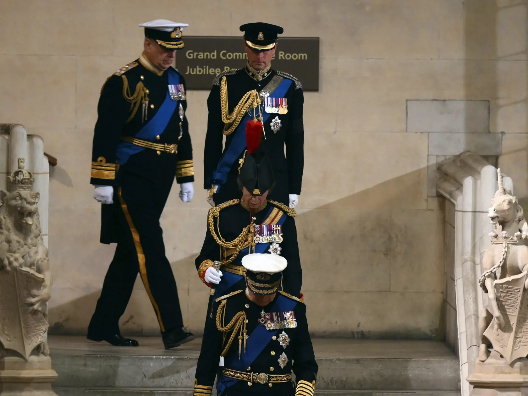Všetci štyria potomkovia zosnulej britskej kráľovnej Alžbety II. - sprava britský kráľ Karol III., princezná Anna, princovia Edward a Andrew  oblečení v slávnostných uniformách - schádzajú po kamennom schodisku na večernú vigíliu do Westminsterskej sály v Londýne v piatok 16. septembra 2022. Dvere Westminsterskej sály zatvoria v pondelok ráno o 06.30 h miestneho času (07.30 h SELČ).